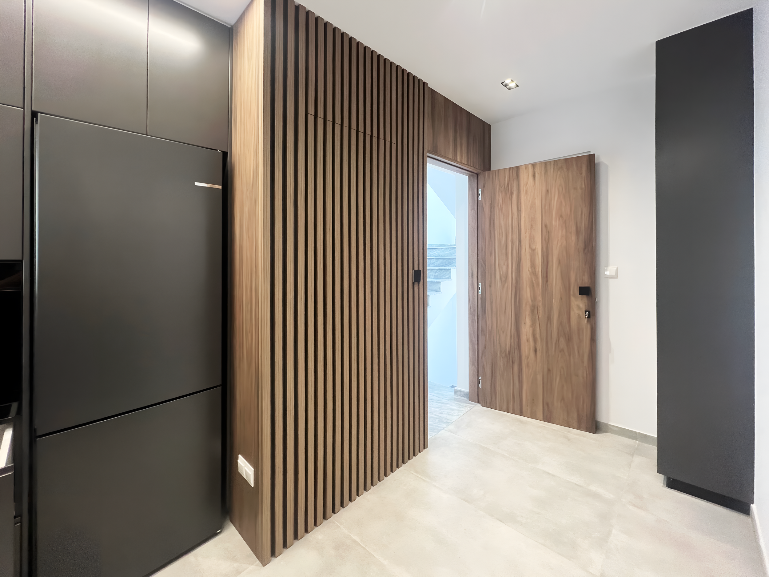 Interior view of a modern room with a wooden wall feature, a doorway leading outside or to another room, and minimalist design elements.