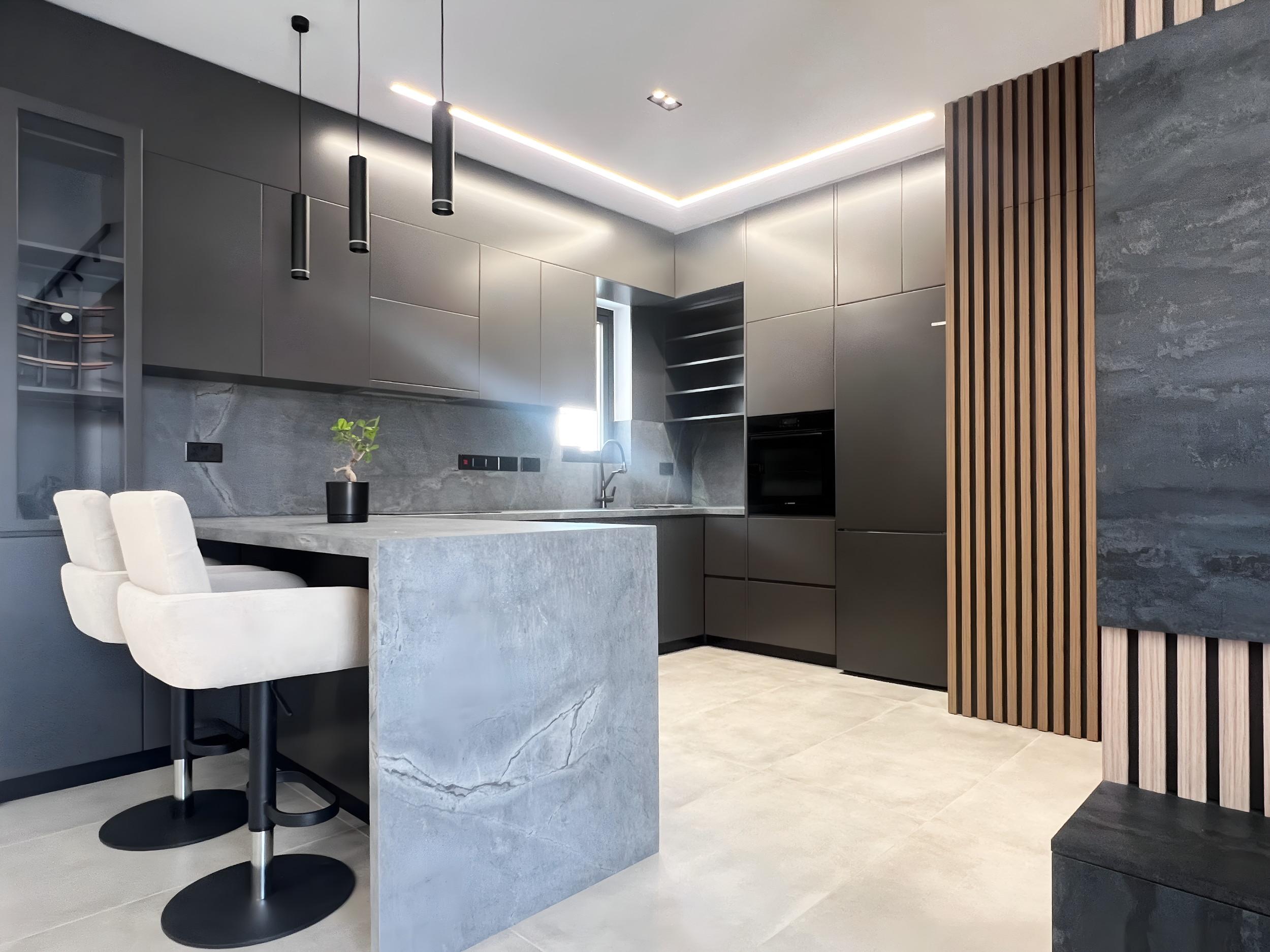 Modern kitchen with gray cabinets, a marble island, black pendant lights, wooden slatted wall panel, and white chairs.