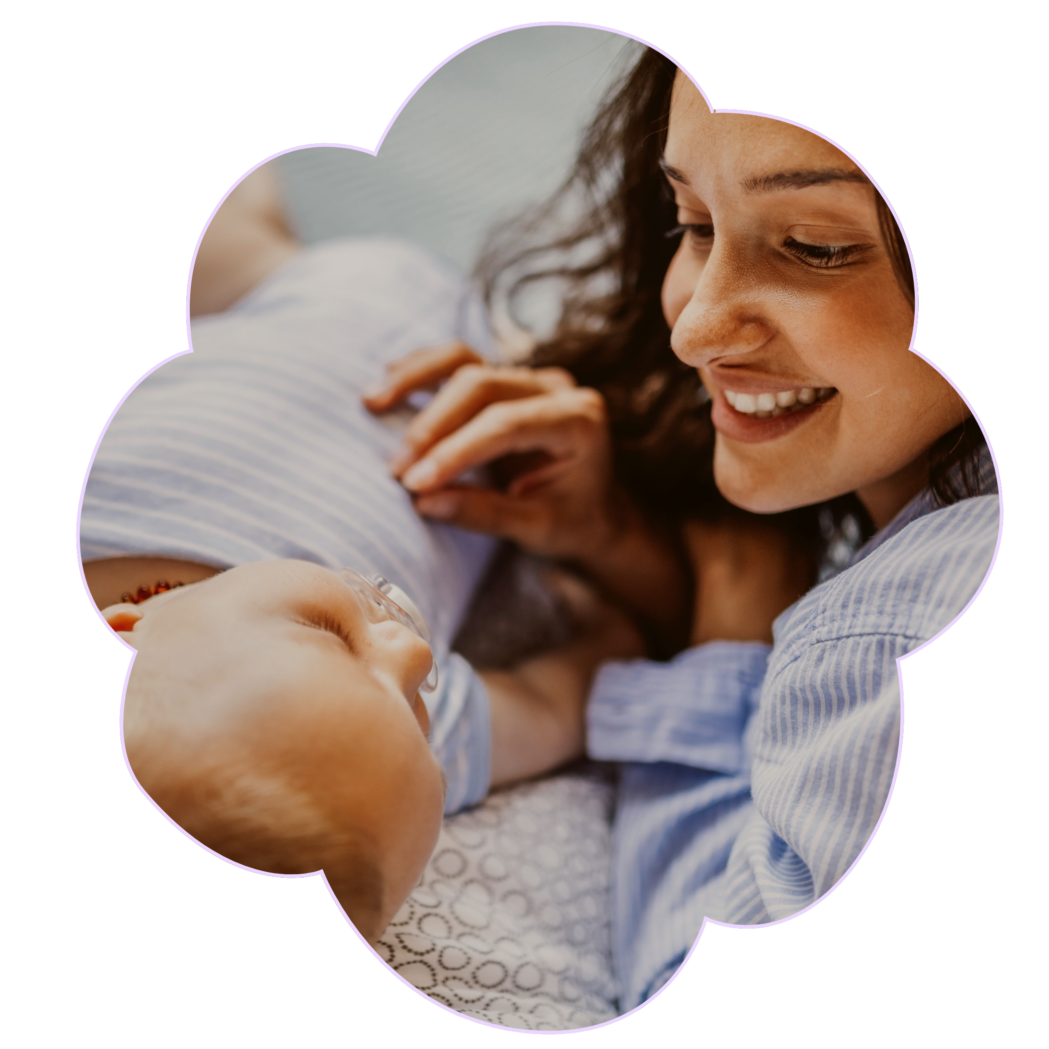 A woman smiling as she looks at her baby laying on their back to represent Strong Roots OT, an occupational therapy clinic in south New Jersey & Philadelphia that specializes in maternal health and pediatrics.