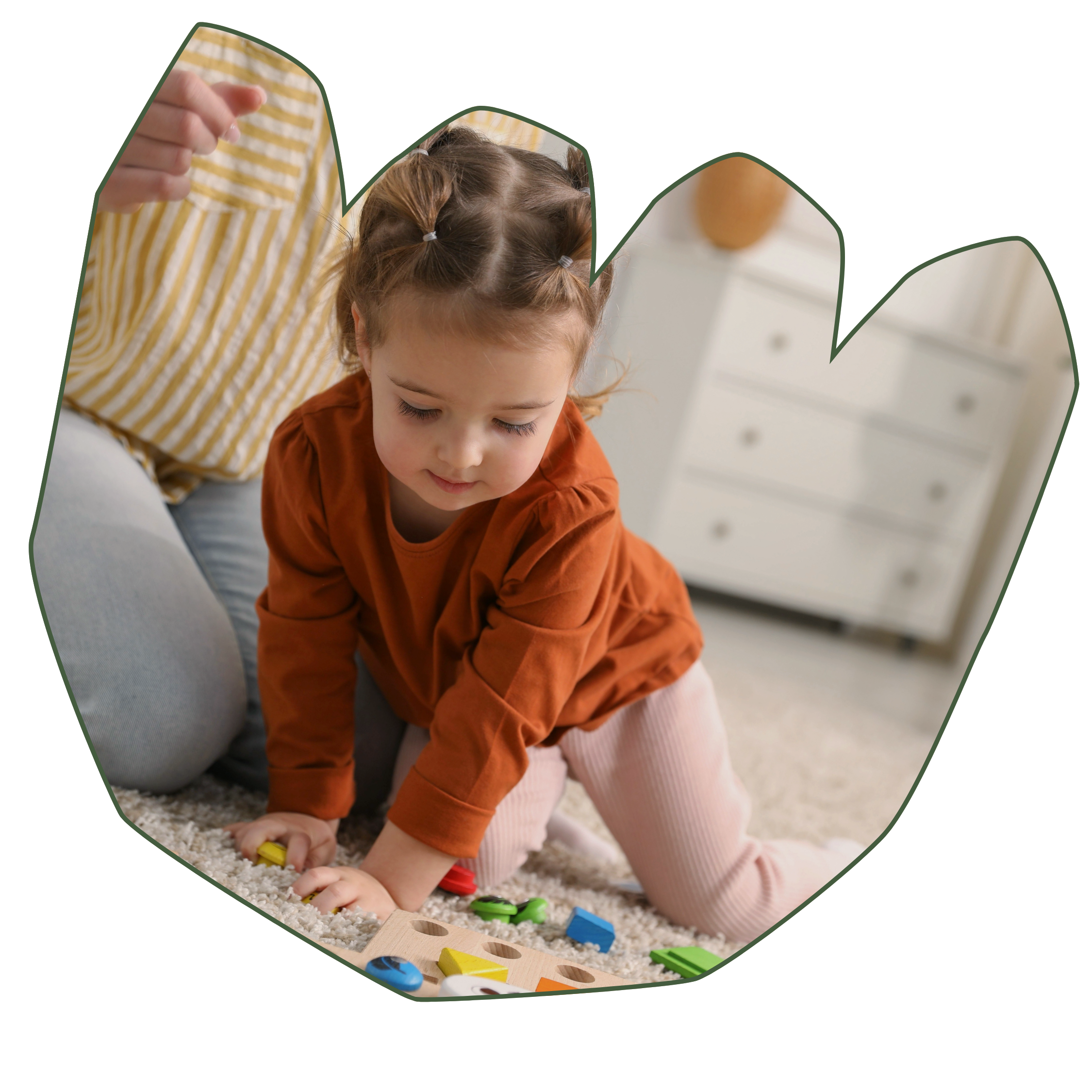 A young girl playing with colorful educational toys on a soft carpet in a bright room in a flower-shaped frame with a green edge because at Strong Roots OT in south NJ and Philadelphia we provide occupational therapy services for toddlers.
