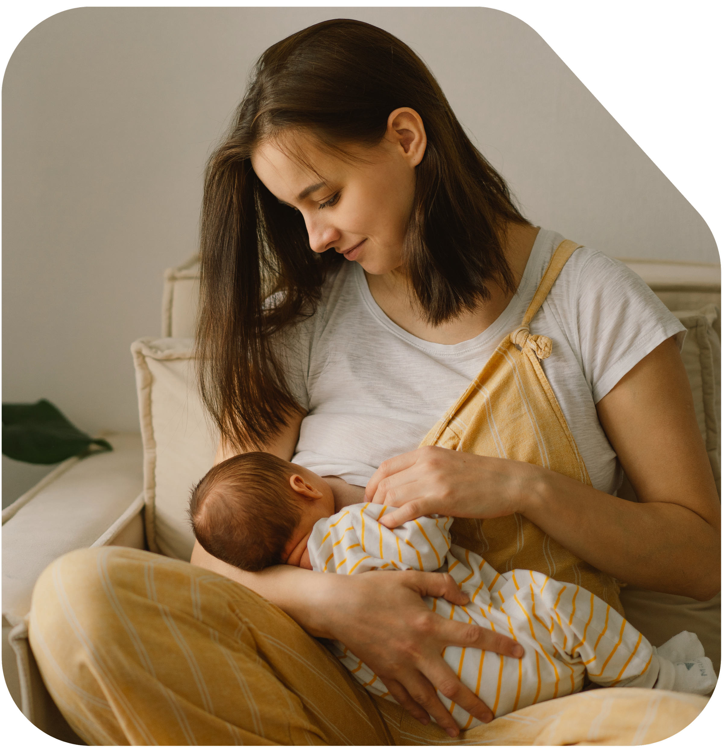 A woman with brown hair looking down affectionately at her baby whom she is breastfeeding. At Strong Roots OT, we provide occupational therapy for mom and baby in south NJ and Philadelphia.