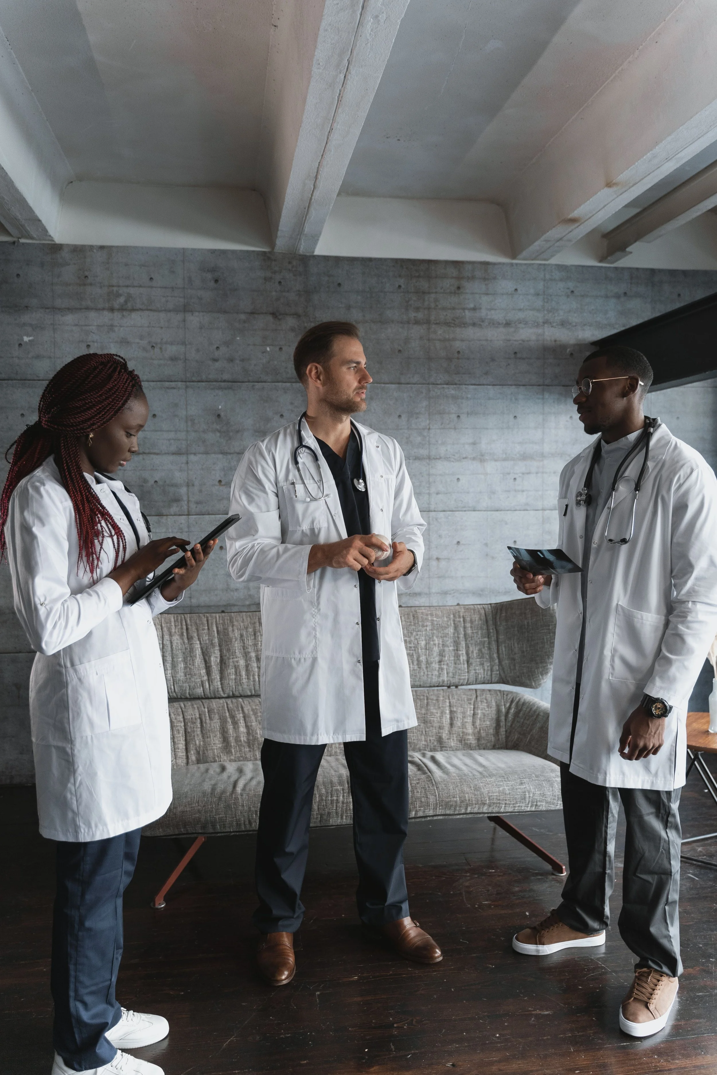 A group of medical professionals collaborates in a healthcare setting, highlighting healthcare executive coaching, physician leadership coaching, and team leadership development for physicians and healthcare executives.