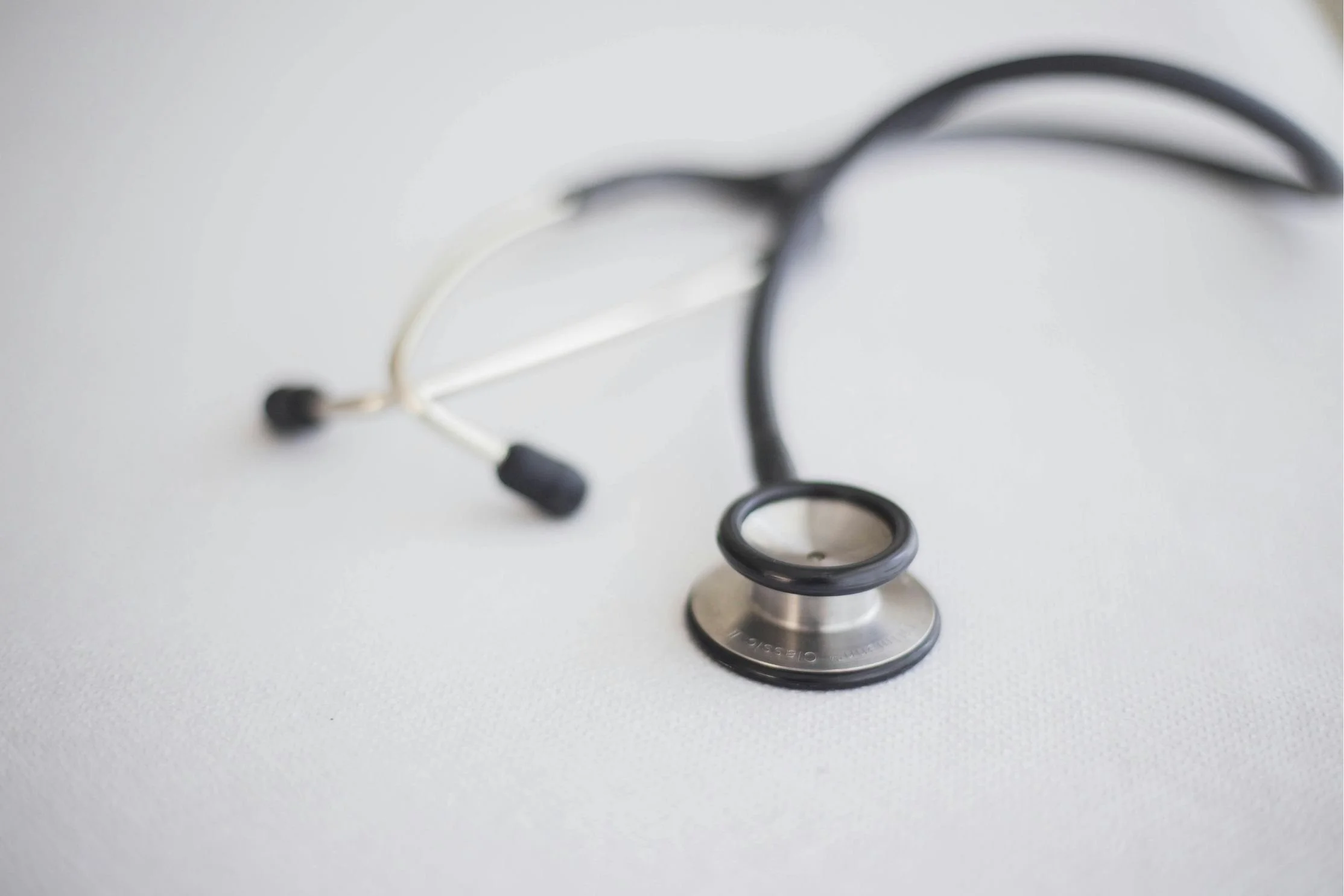 Close-up of a stethoscope resting on a white surface, symbolizing healthcare, patient care, and medical diagnostics.
