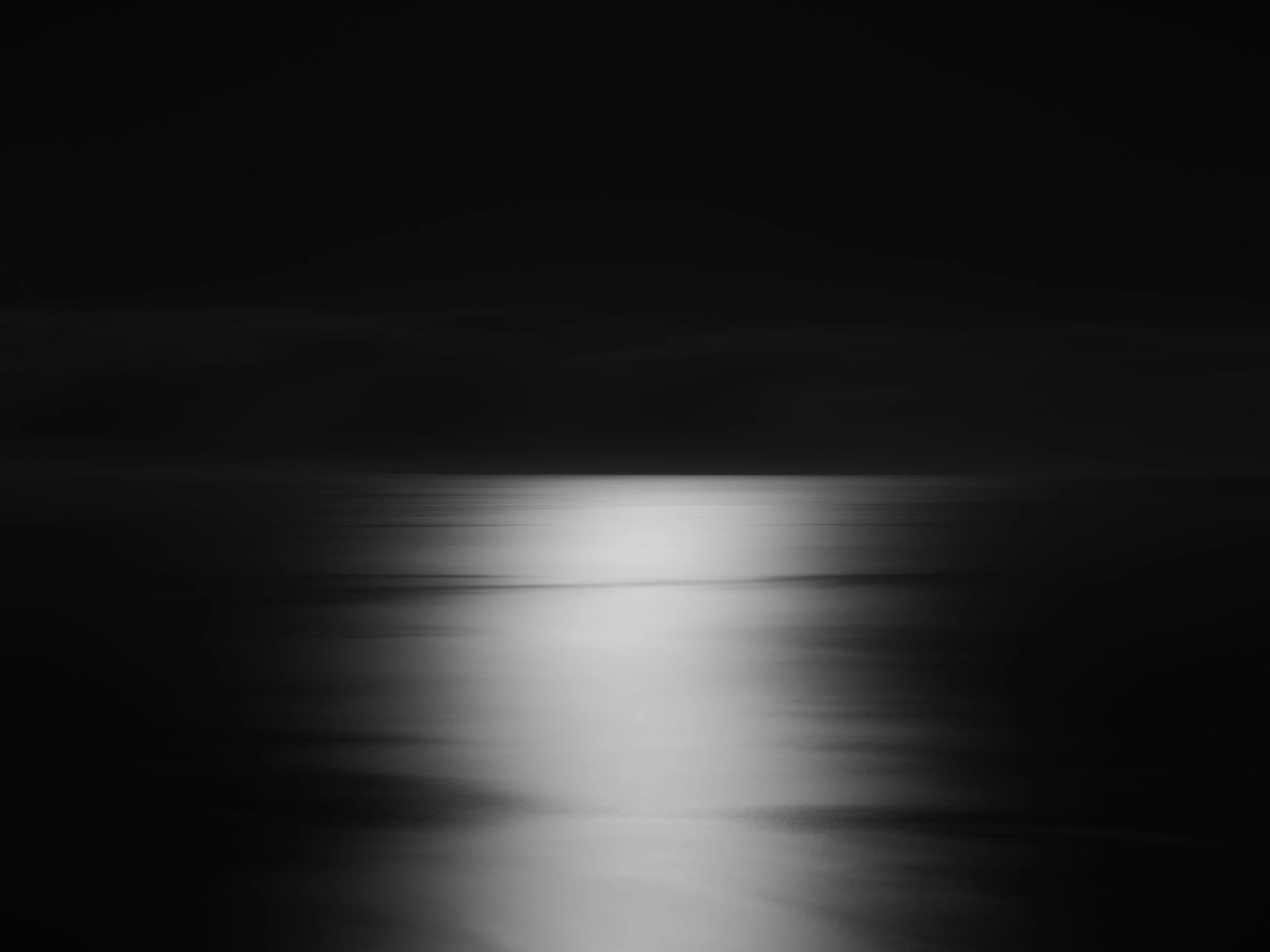 Black and white photograph of the moonlight on the Atlantic Ocean, Lisbon, Portugal. Made by Indigenous Design and Photography Ltd.
