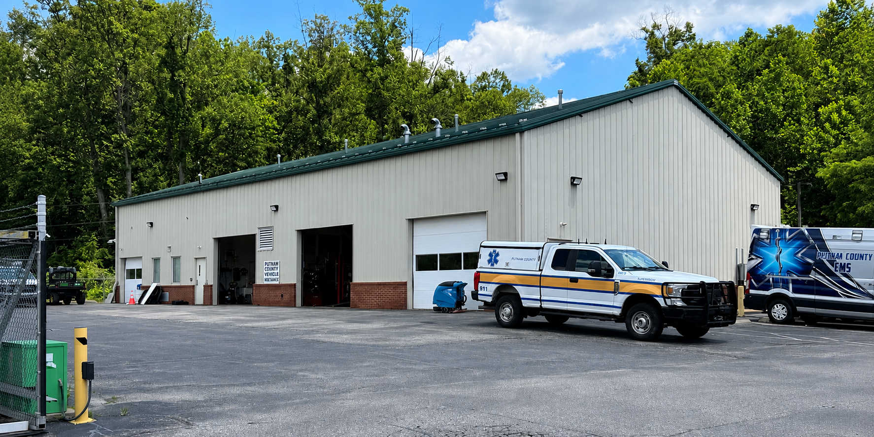 Putnam County emergency services storage and vehicle maintenance building with county signage, EMS vehicles, and paved parking area.