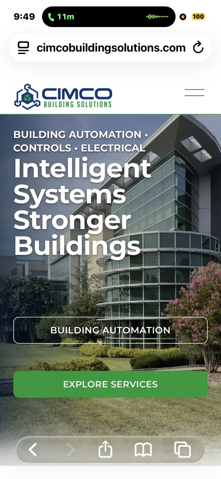 Screenshot of a website homepage for CIMCO Building Solutions showing a modern office building with glass windows, trees, and a lawn. The webpage promotes building automation, controls, electrical, and intelligent systems for stronger buildings with a large green "Explore Services" button.