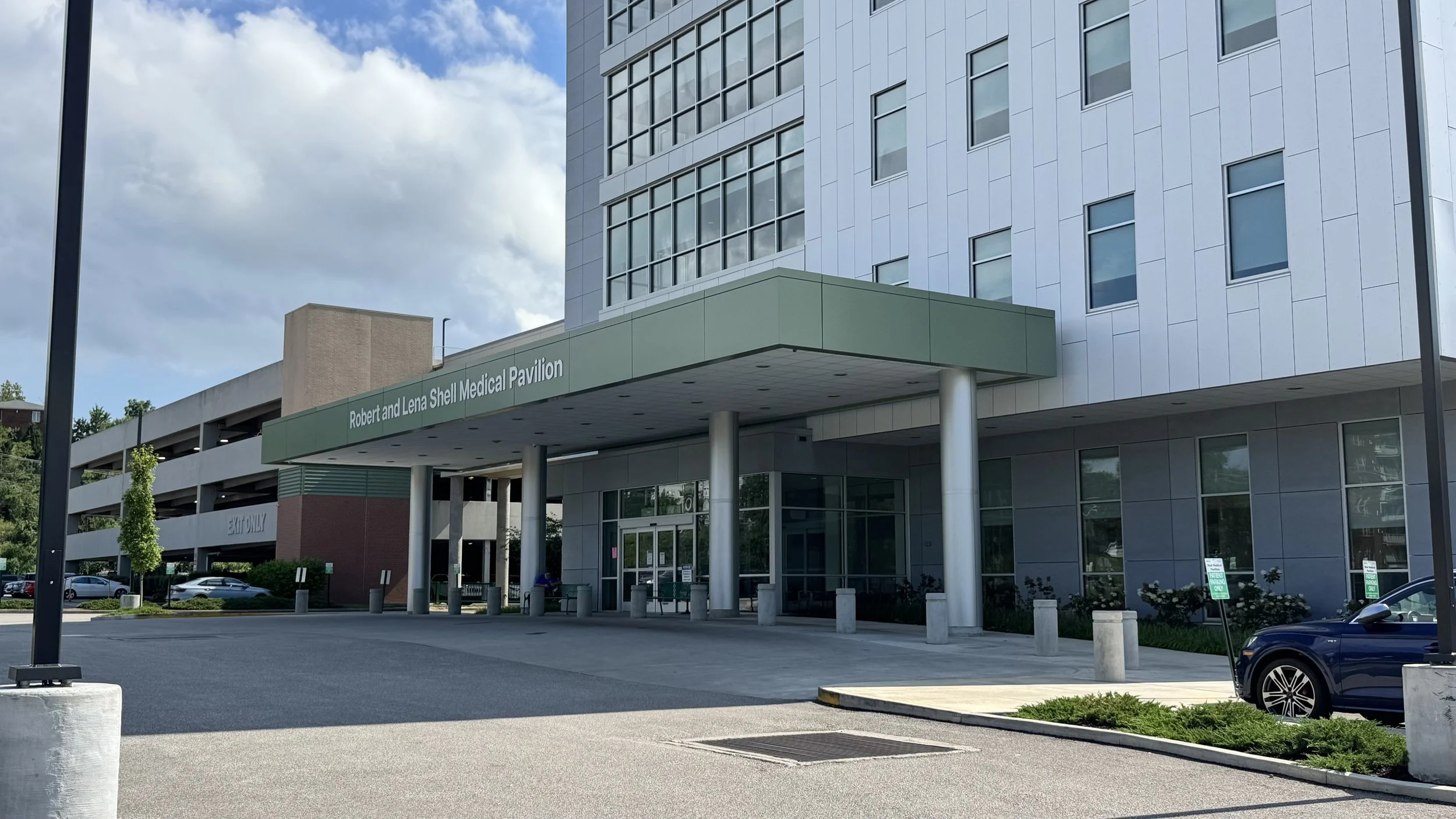 Exterior of Robert and Lena Shell Medical Pavilion with a parking lot and a clear sky.