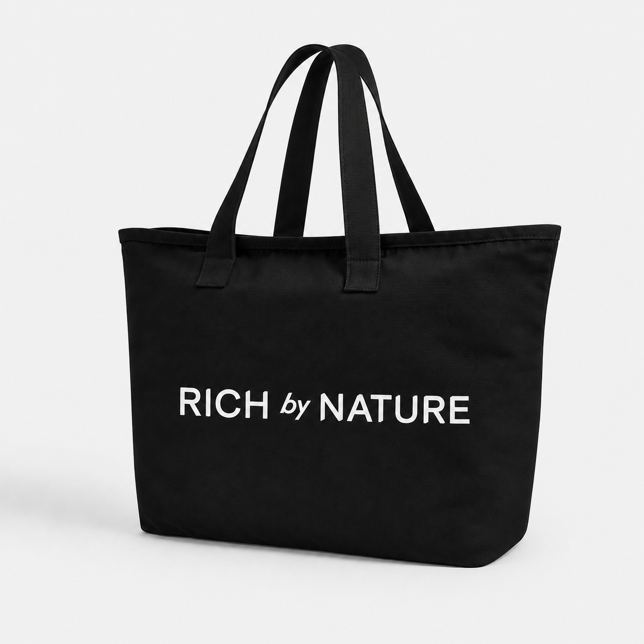 En svart veske med teksten 'RICH by NATURE' skrevet på.
