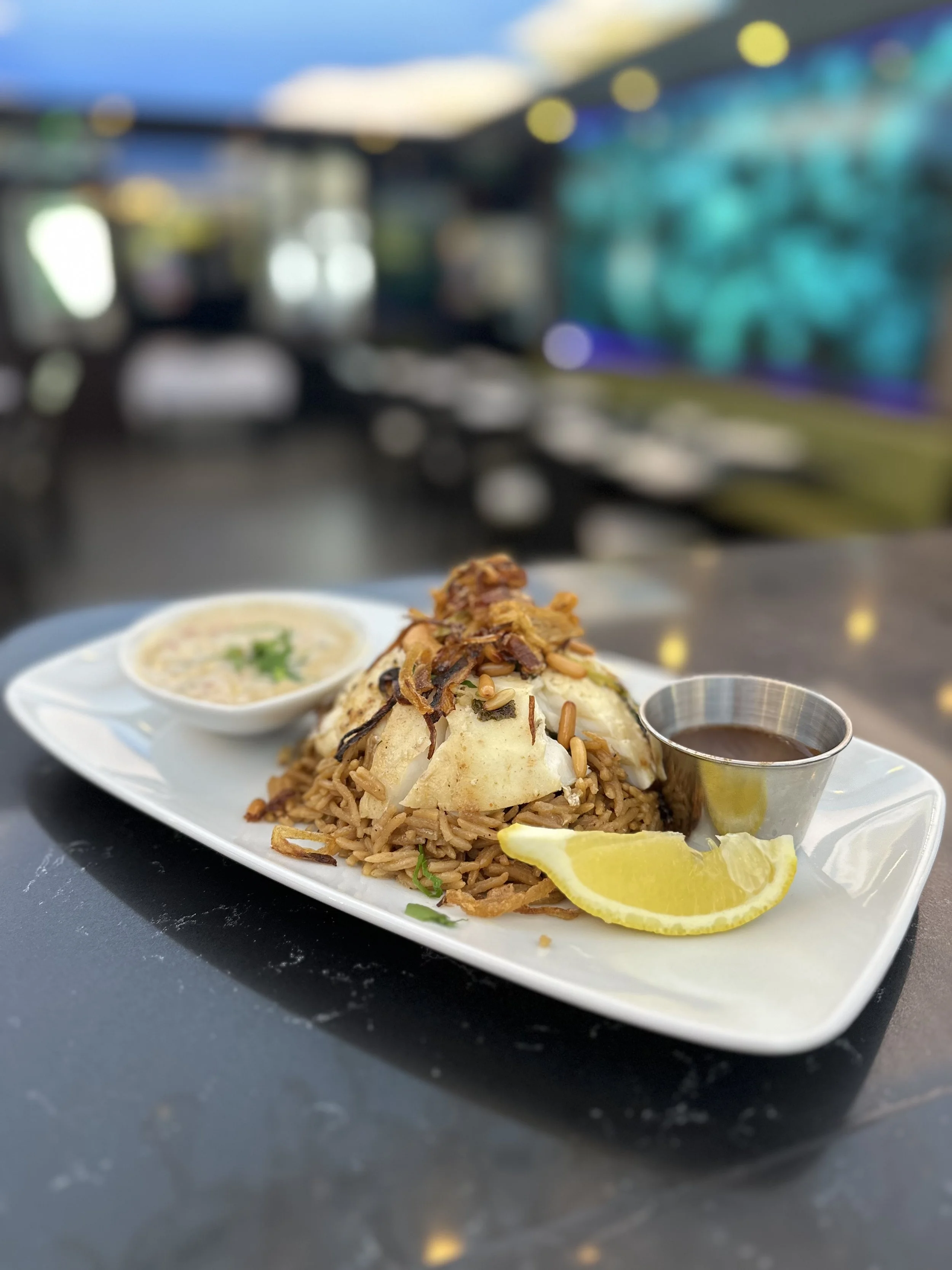 Traditional main course from Lebanon called Siyadieh made of cod fish fillets and caramelised onion rice