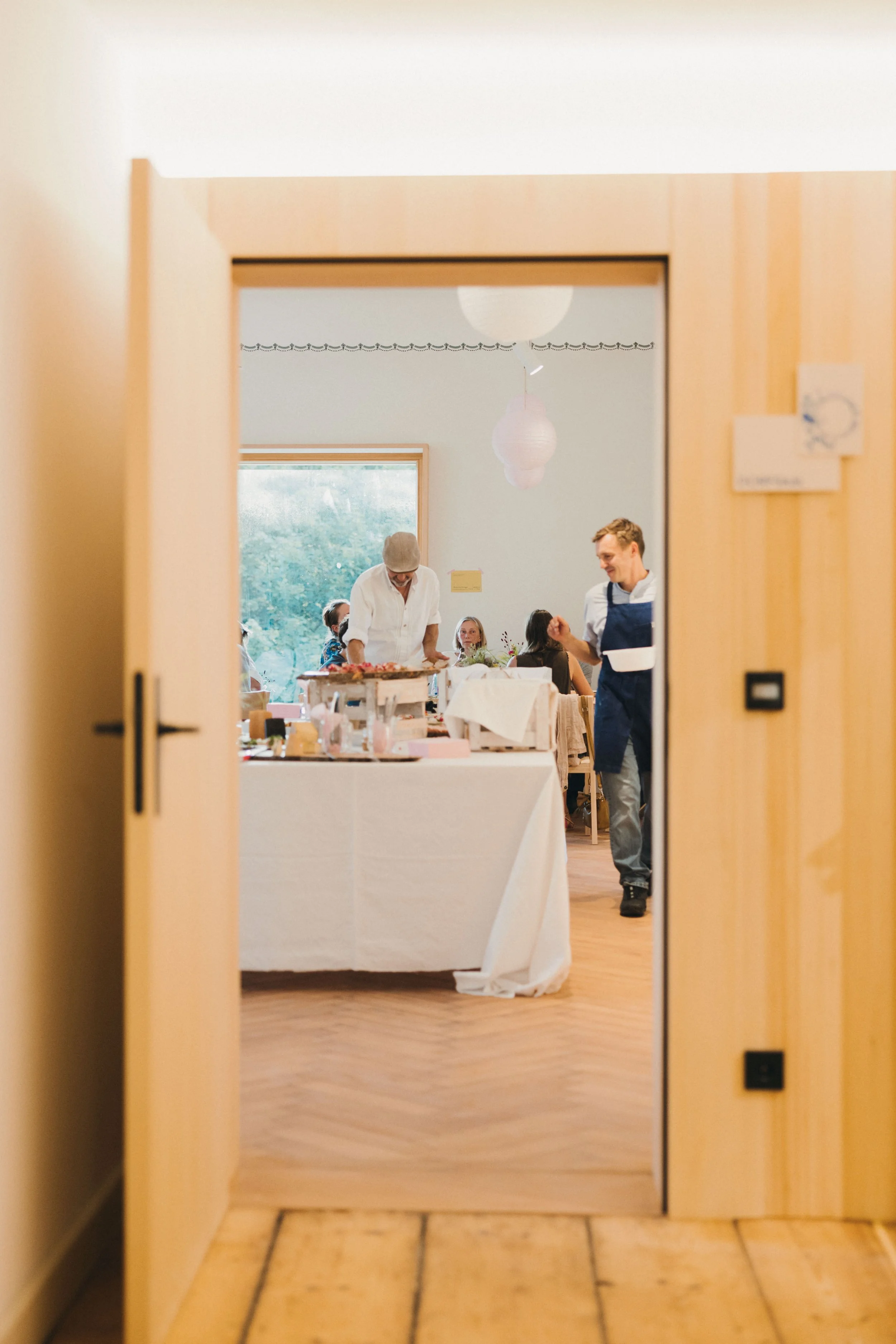 Ein Blick durch die schöne Tür zum Dorfsaal der Alten Schule in Bühl. Im festlich gedeckten Dorfsaal wird gibt es ein Buffet.
