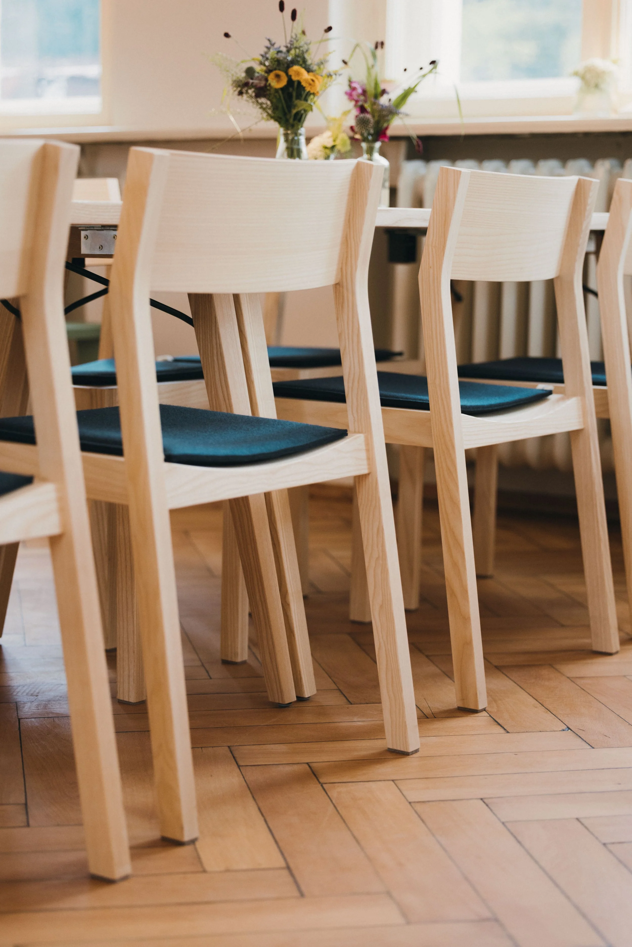 Die schönen Tische und Stühle aus Holz verleihen den Räumen der Alten Schule in Bühl eine warme und einladende Atmosphäre.
