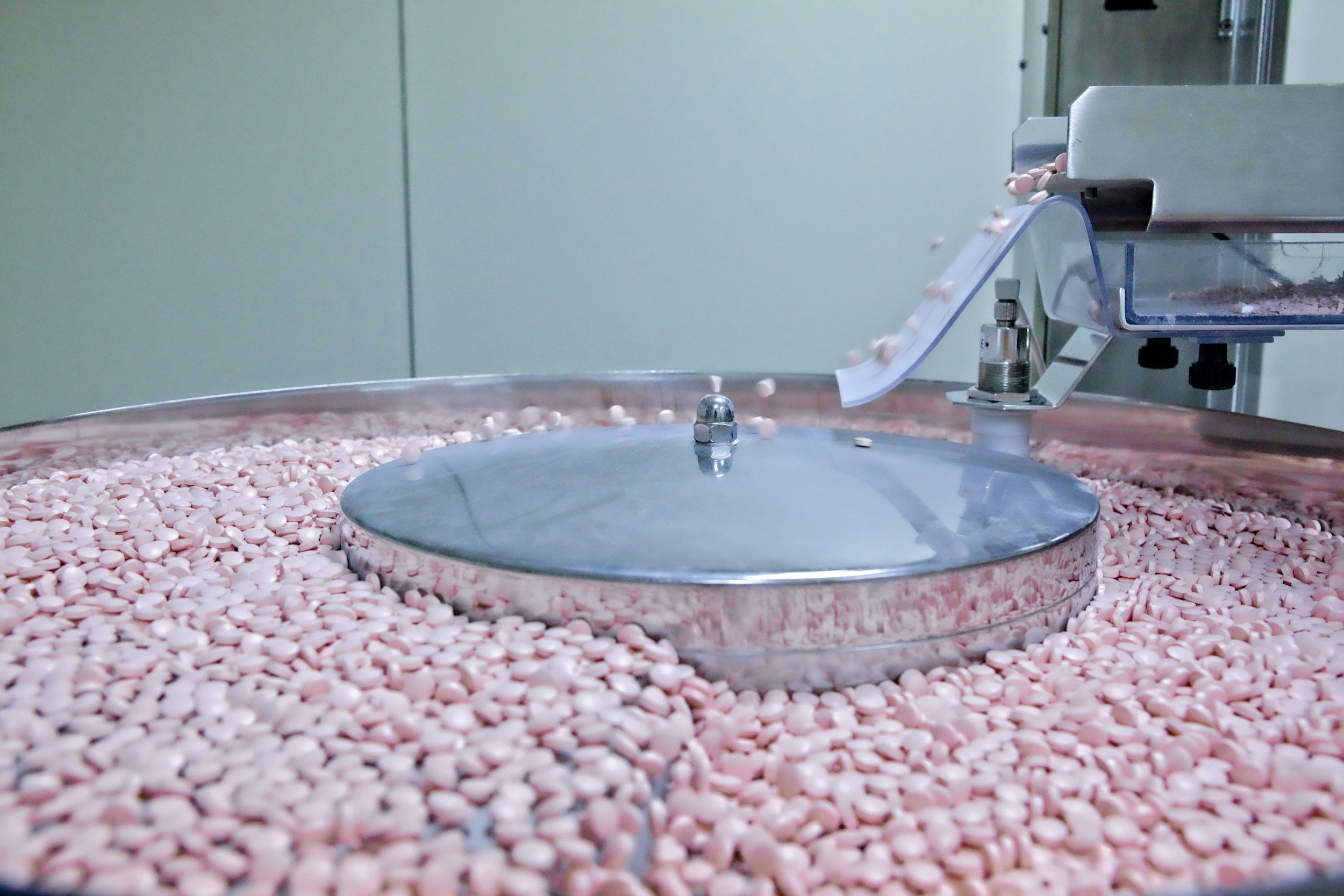 Tablets in a pharmaceutical coating pan on a manufacturing line