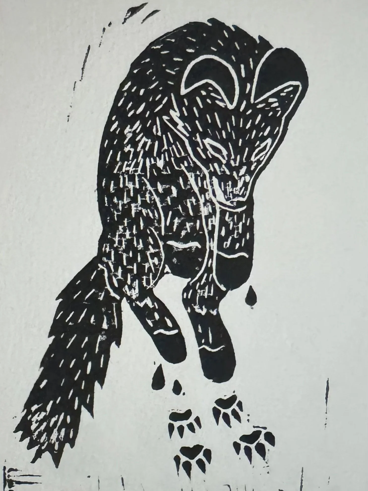 A black and white lino print of a fox jumping with foot prints.
