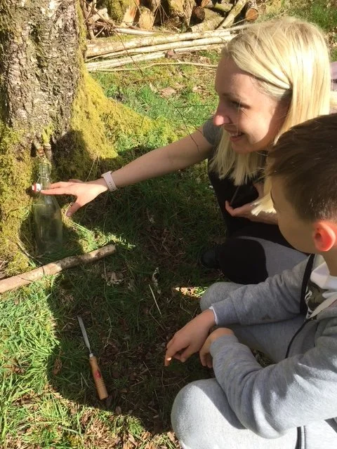 A woman and child learning bushcraft skills