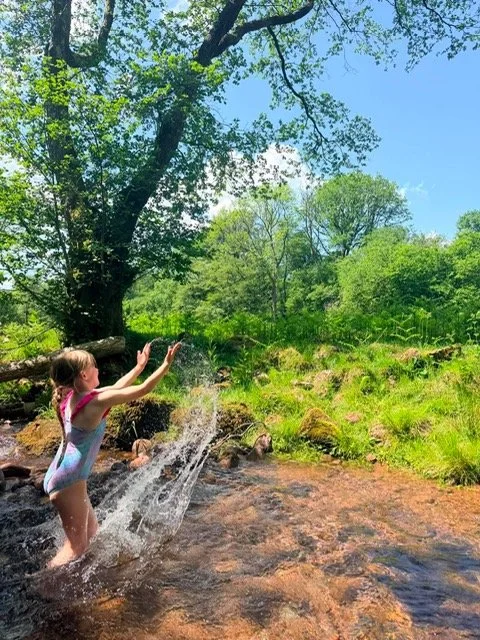 A young visitor playing in the river