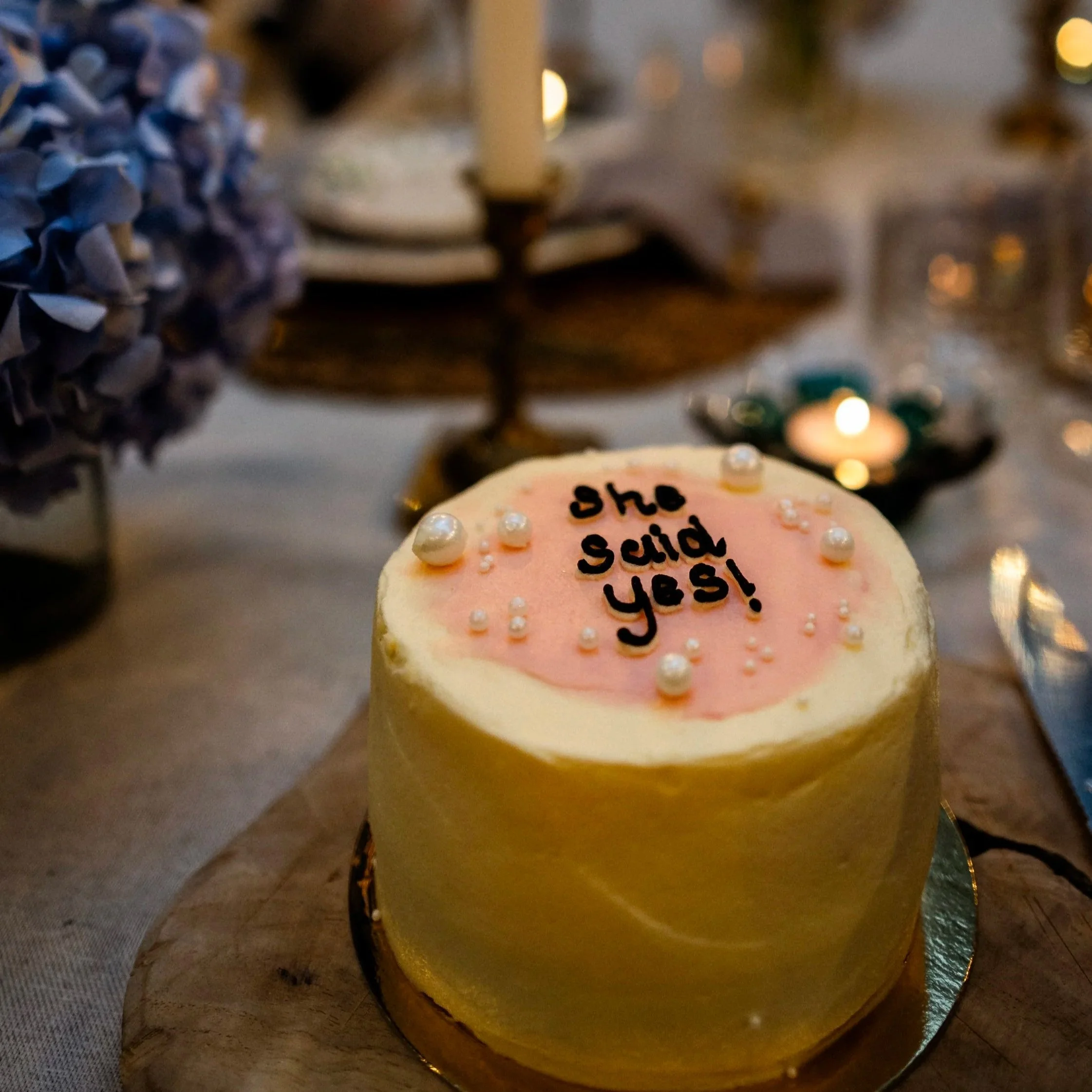 Personalised cake reading "She said yes!" after a marriage proposal at La Roulotte.
