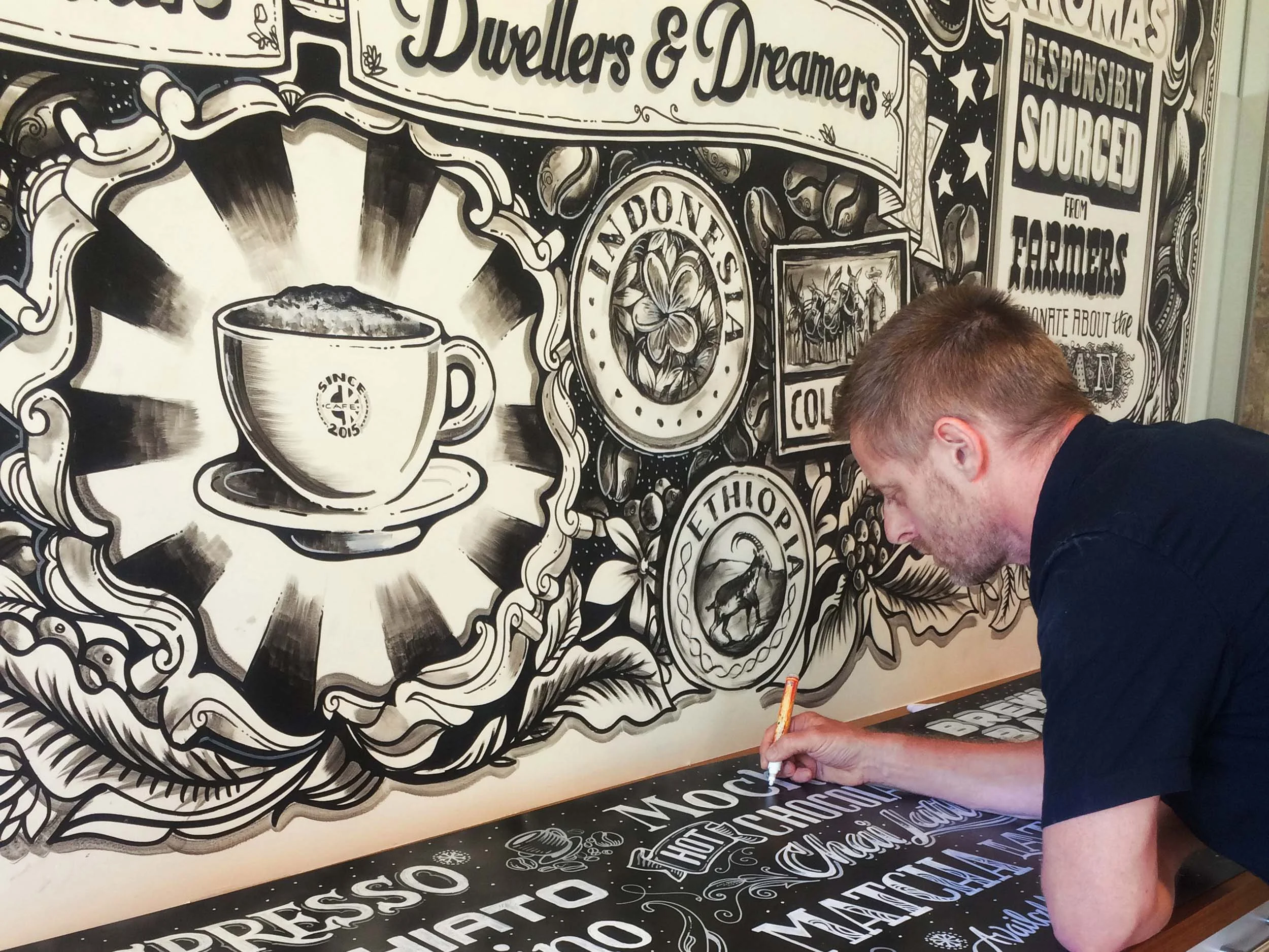 Vic Lee hand painting a large-scale storytelling mural for Credit Karma