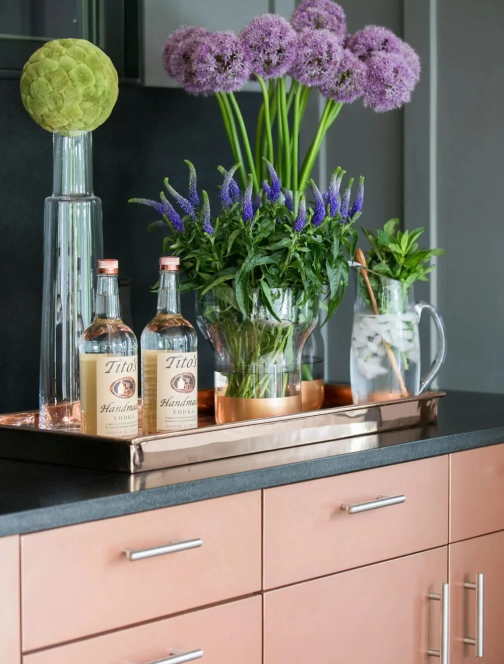 Color of the day is copper colored cabinetry.  This bar set up looks fresh with mint from the garden.  Black granite countertops is a nice contrast with the copper.
#luxuryliving #customcabinetry #modernrusticdesign #interiordesign #designerdeb