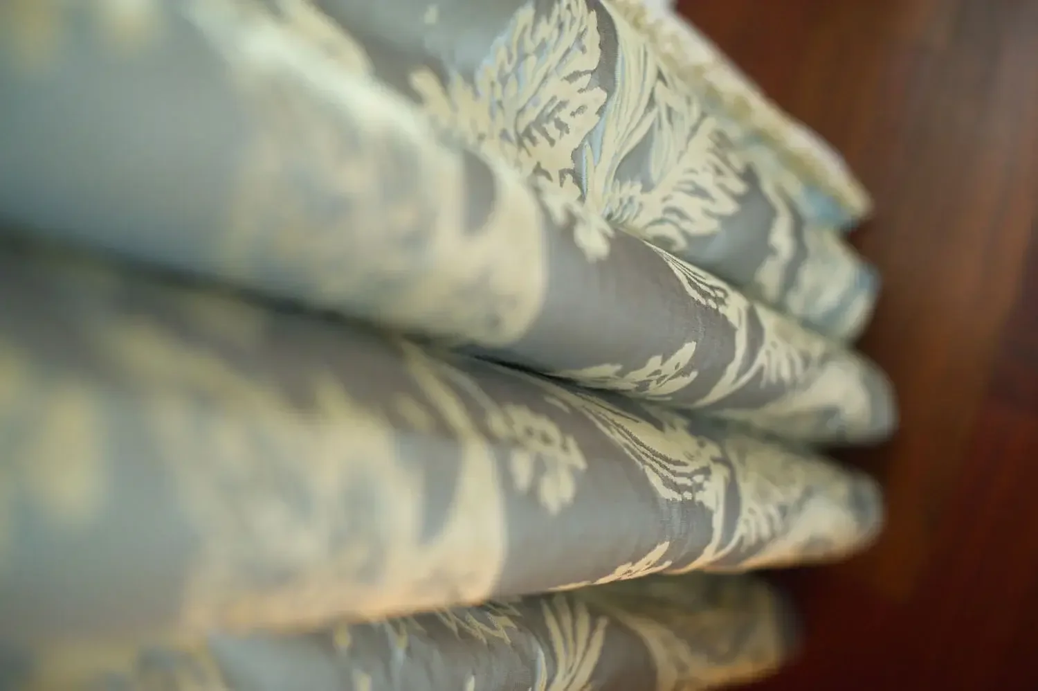 Close-up of folded fabric with a blue and cream floral pattern.