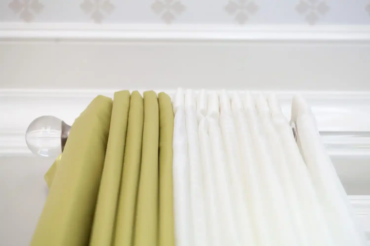 Close-up of stacked white and yellow fabric straps or belts on a white rail.