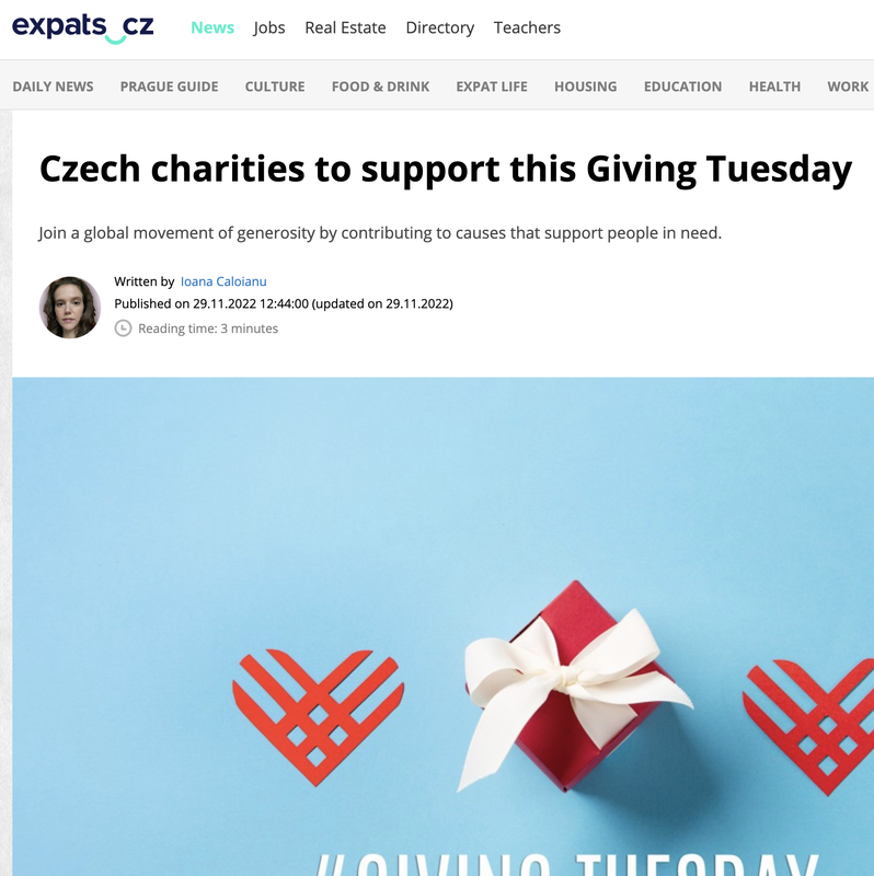 A festive image with a small red gift box wrapped with a white ribbon on a light blue background, flanked by two red heart-shaped symbols, associated with Giving Tuesday charity event in Czech Republic.