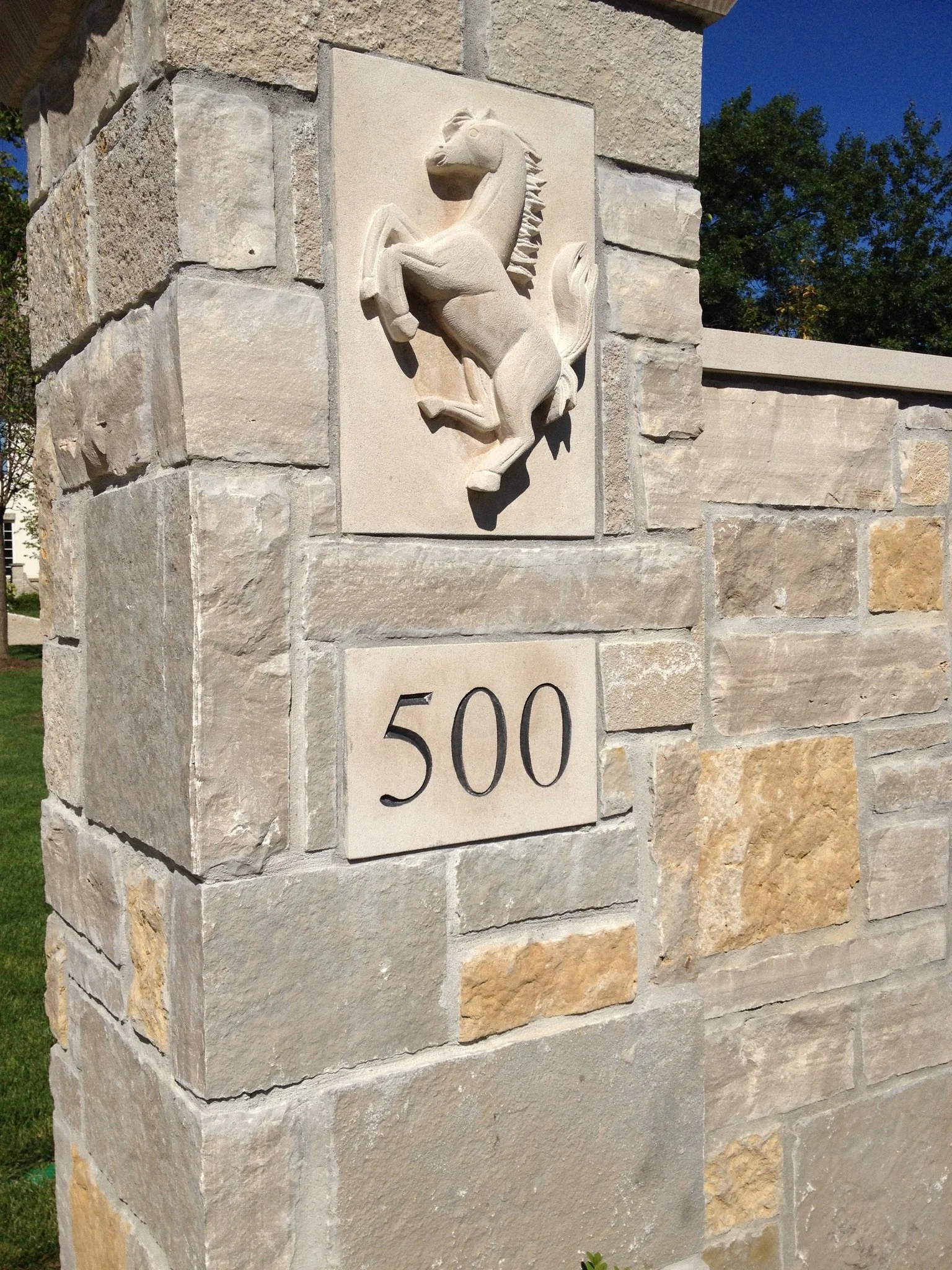 A stone wall with a relief sculpture of a horse and number 500.