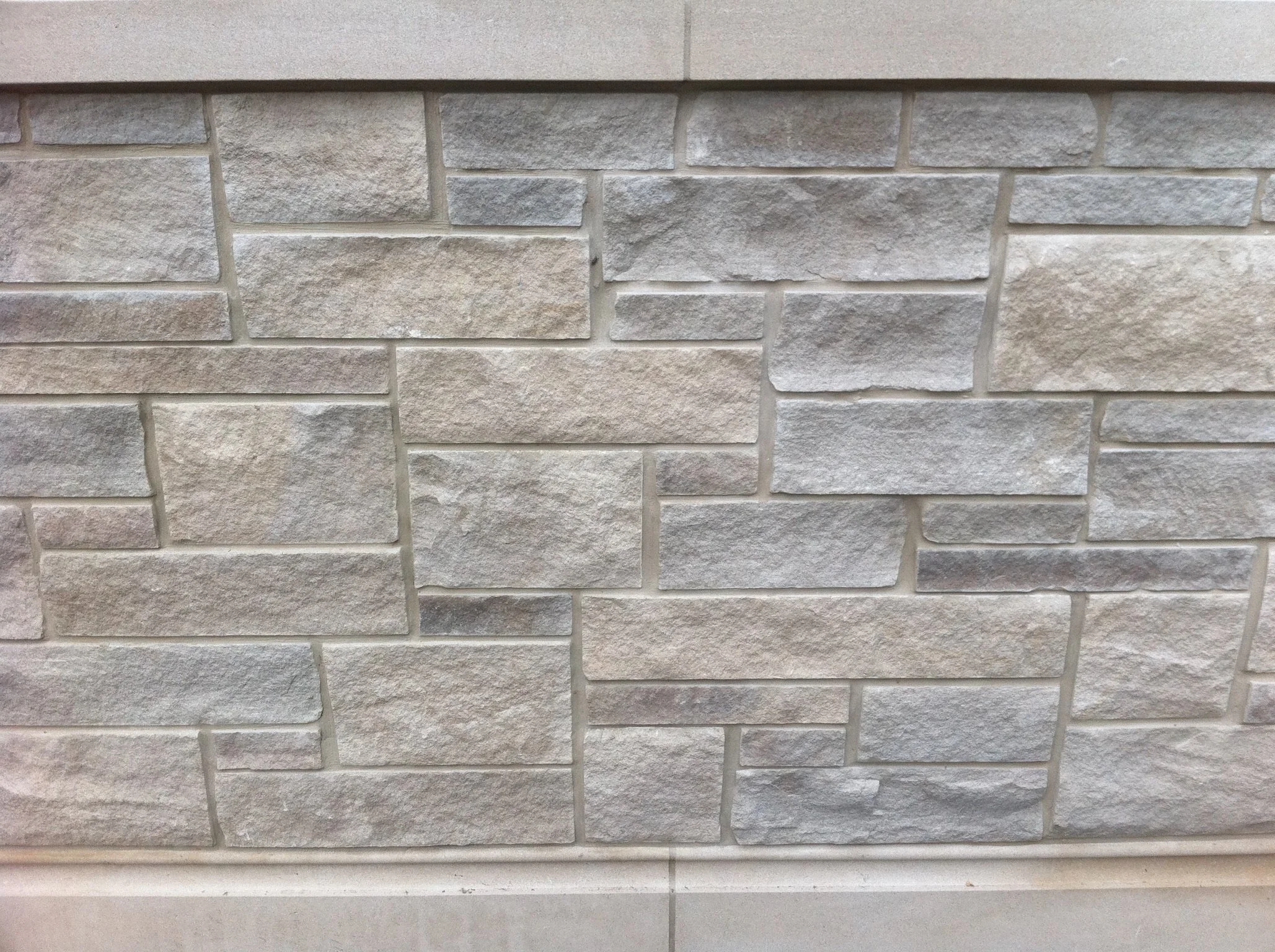 Close-up of a textured beige brick wall with horizontal mortar joints.