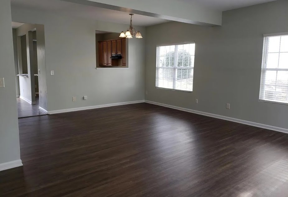 Empty rental unit dining area featuring dark wood floors and a hanging light. Tenant placement services in Apex, NC.