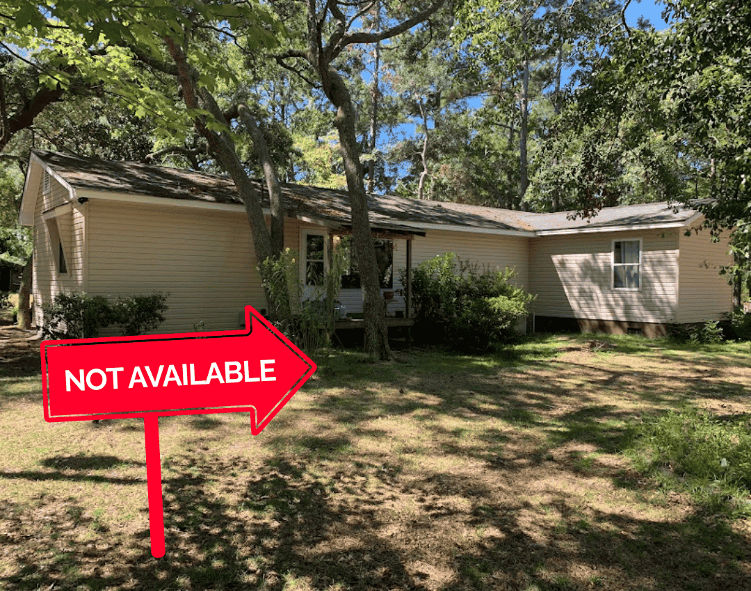 Shaded backyard lawn and rear view of a single-family house. Property management company in Southport, NC.
