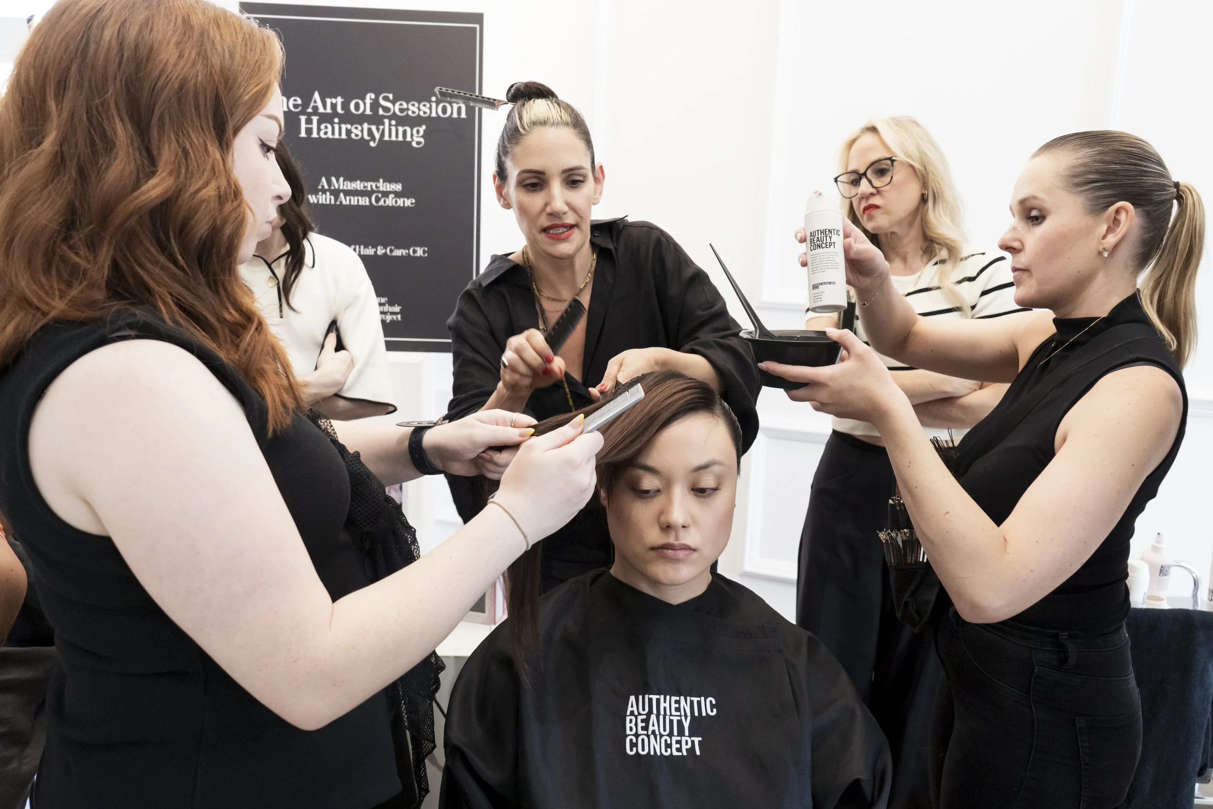 Anna Cofone leads a demonstration at The Masterclass, using a live model while other hairstylists participate