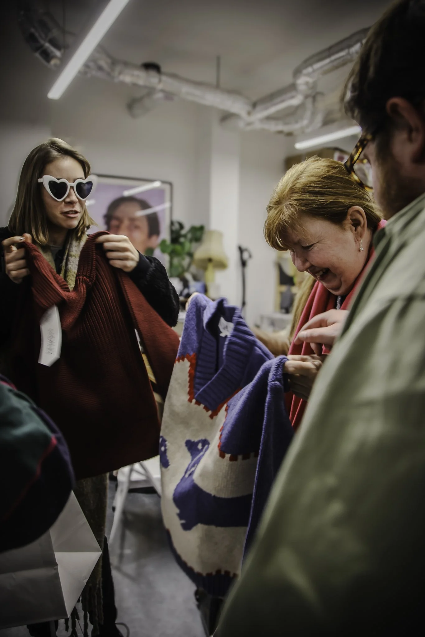 Guests at a touch tour, feeling garments, and exchanging with one another.