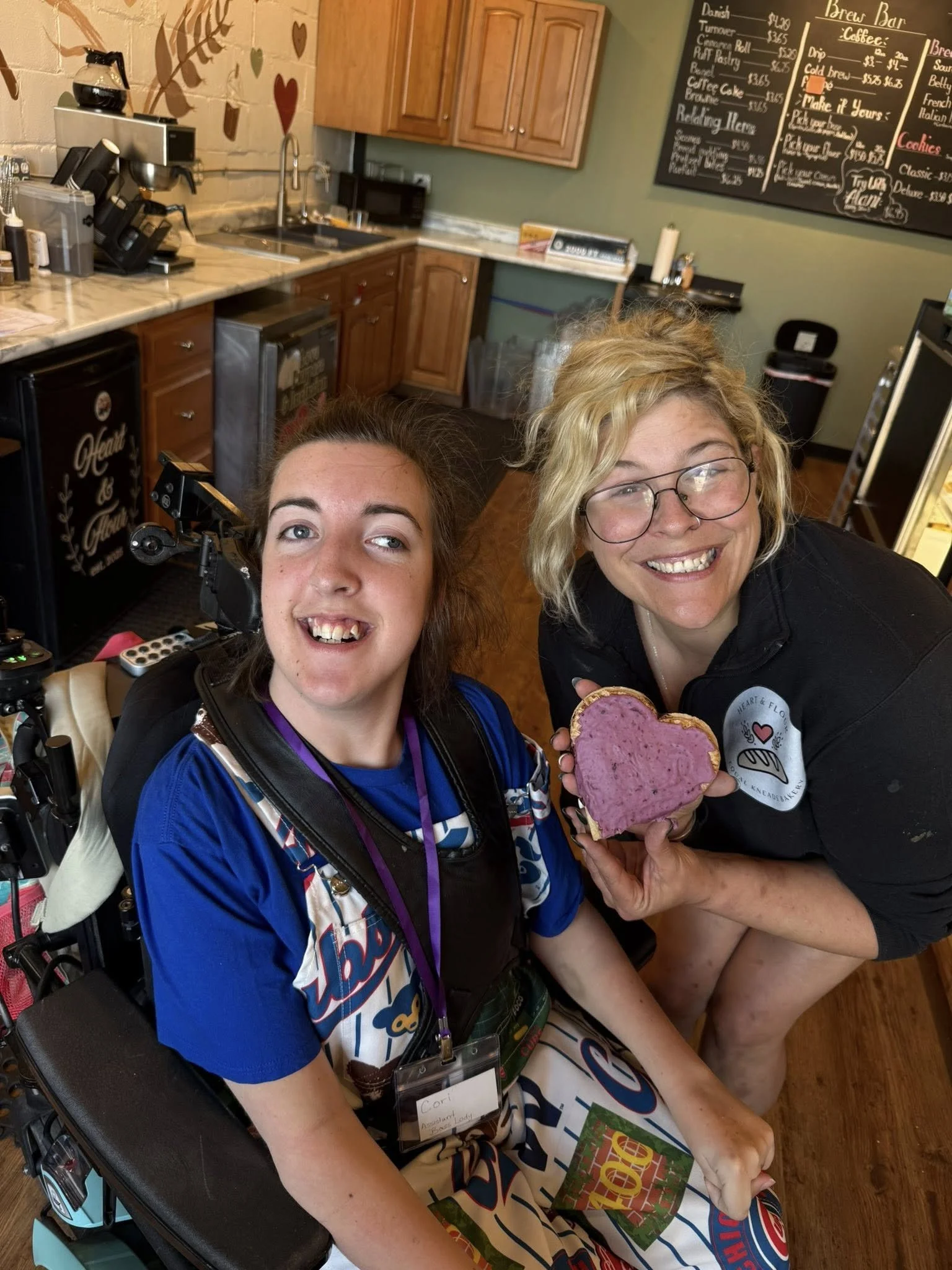 Two women in a bakery, smiling and posing for a photo.