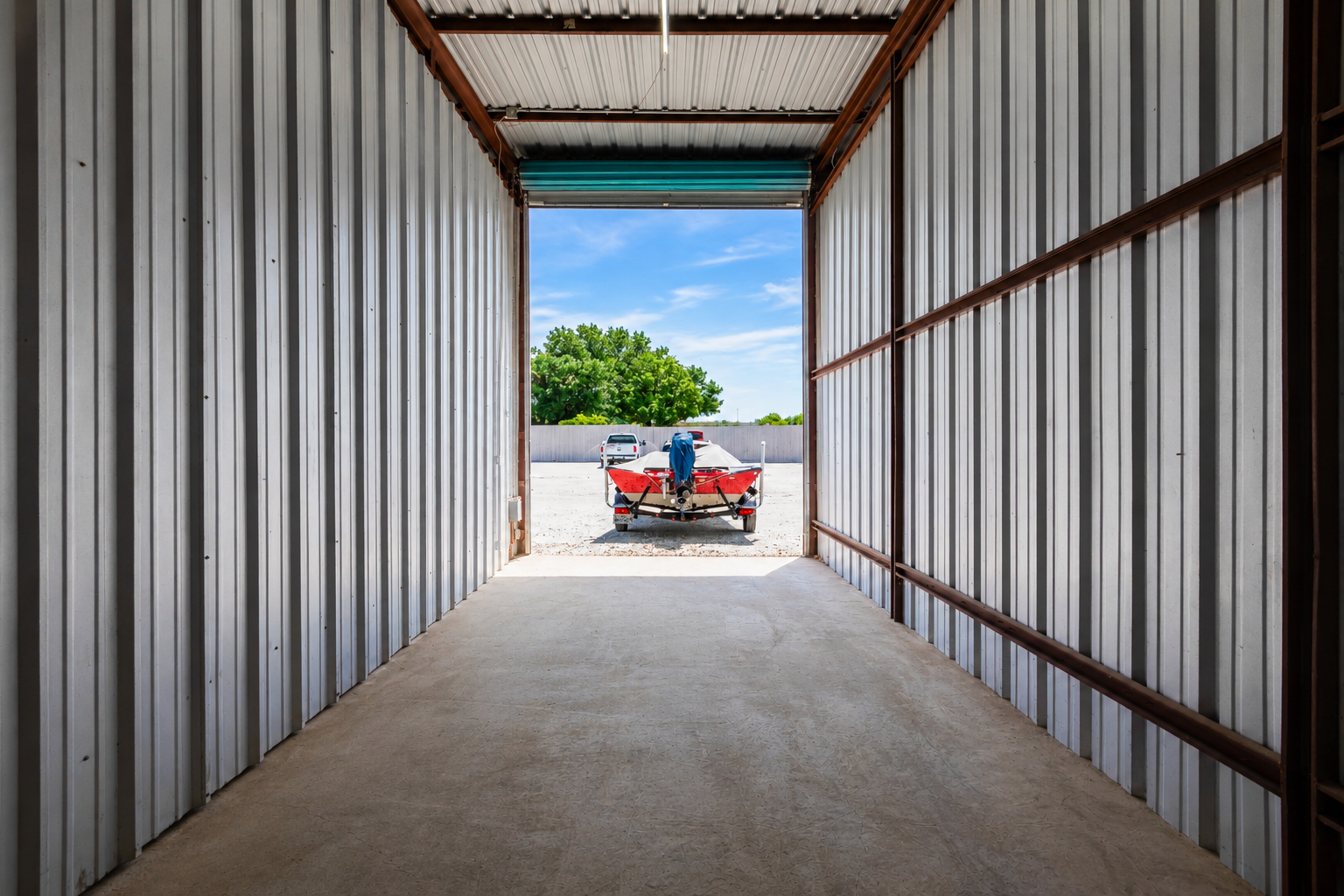 View from inside an enclosed unit in Wylie, TX looking out toward a boat on a trailer parked outside