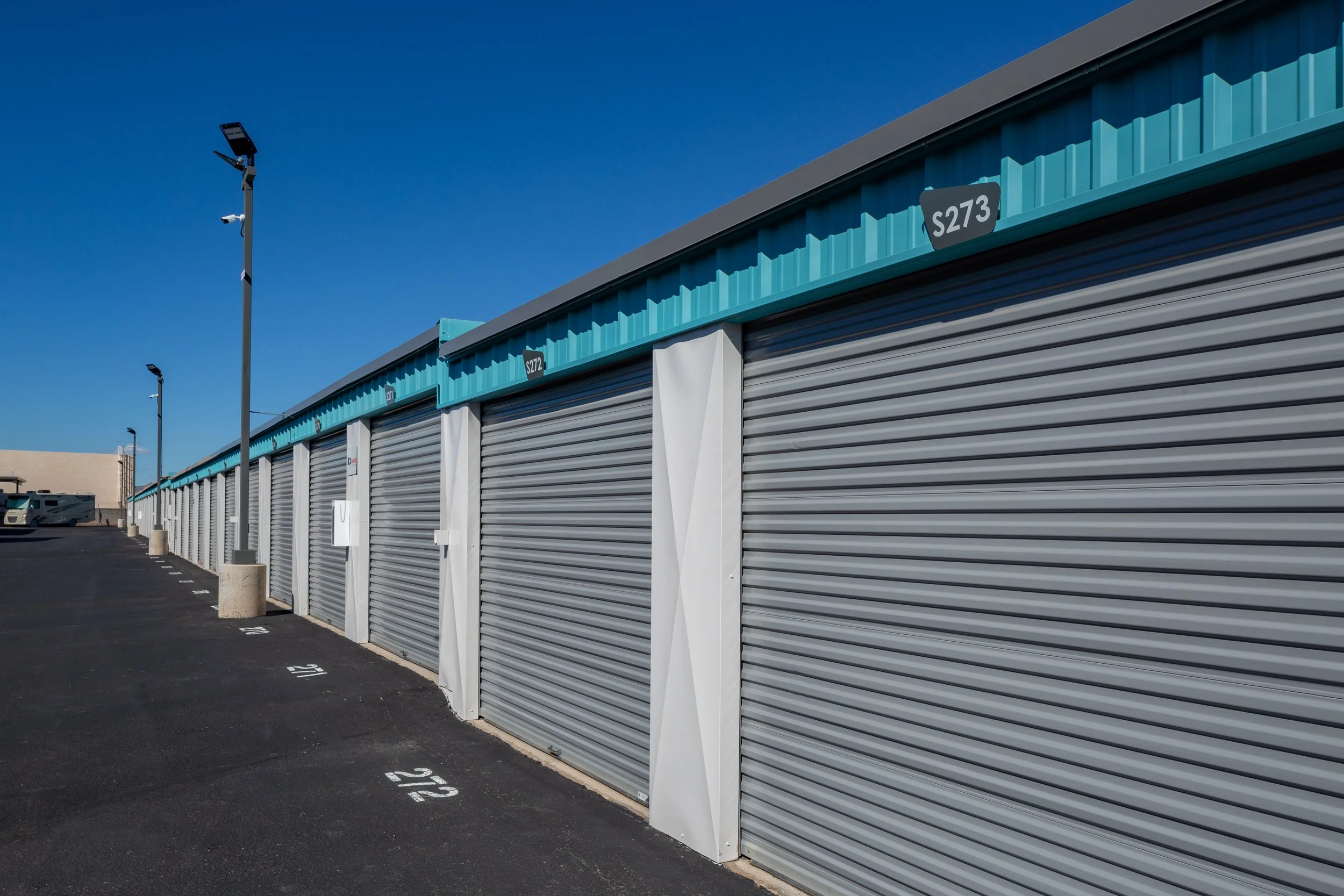 Long row of fully enclosed RV garage units receding down the drive aisle at Carefree Covered RV Storage in Apache Junction, AZ