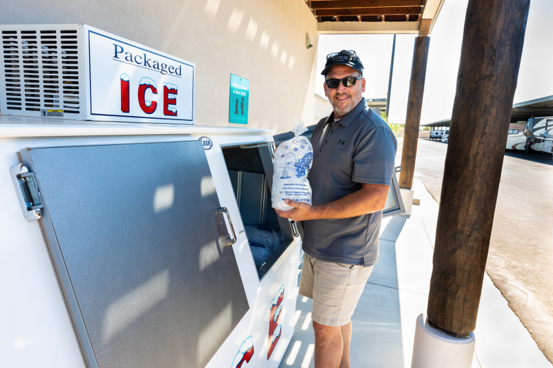Customer picking up free packaged ice at Carefree Covered RV Storage's Chandler Kyrene Rd welcome center