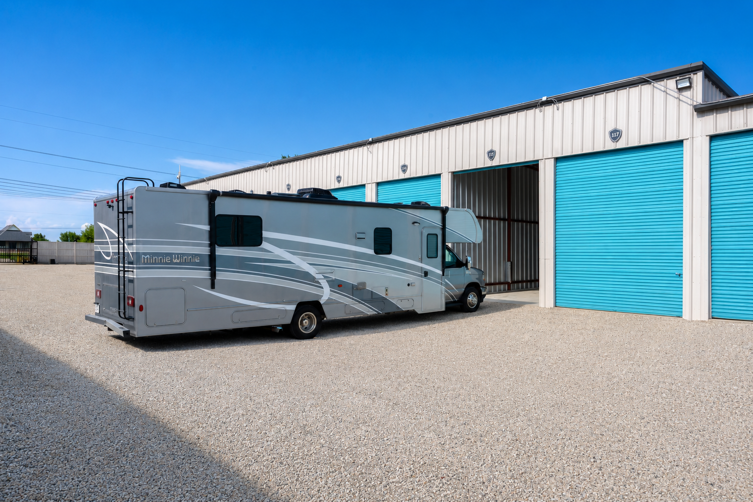 Class C motorhome backed into an enclosed teal storage unit at Carefree Enclosed Boat & RV Storage, Wylie, TX