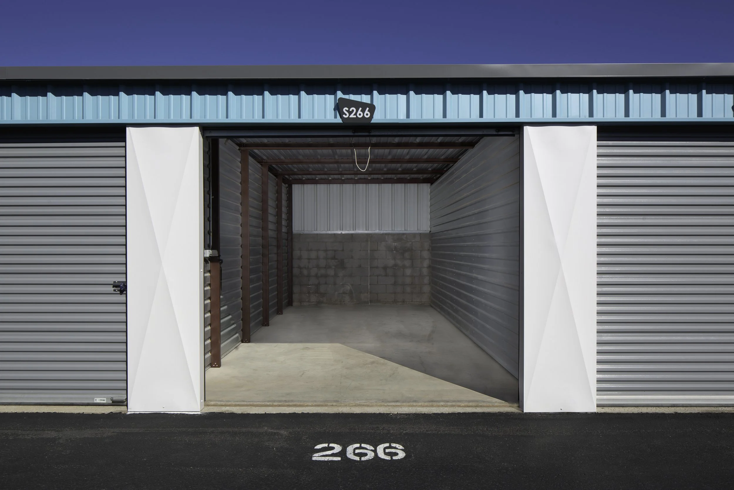 Interior view through an open enclosed RV garage door showing four-wall construction at Carefree Covered RV Storage, Apache Junction, AZ