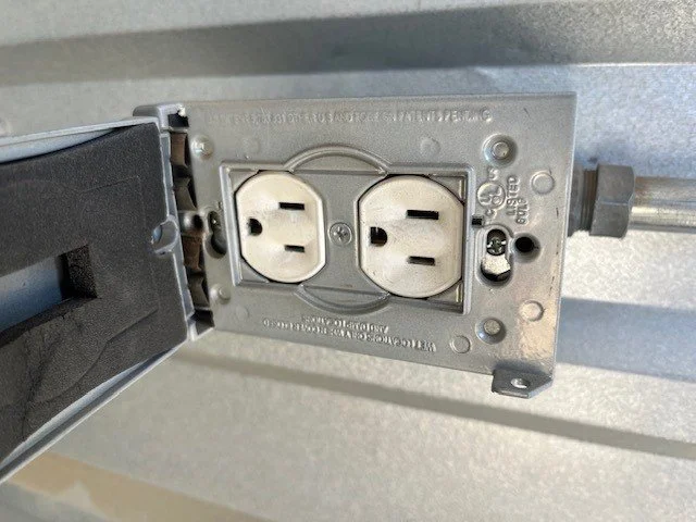Close-up of the power outlet installed inside an enclosed vehicle storage unit at Carefree Covered RV Storage in Apache Junction, AZ