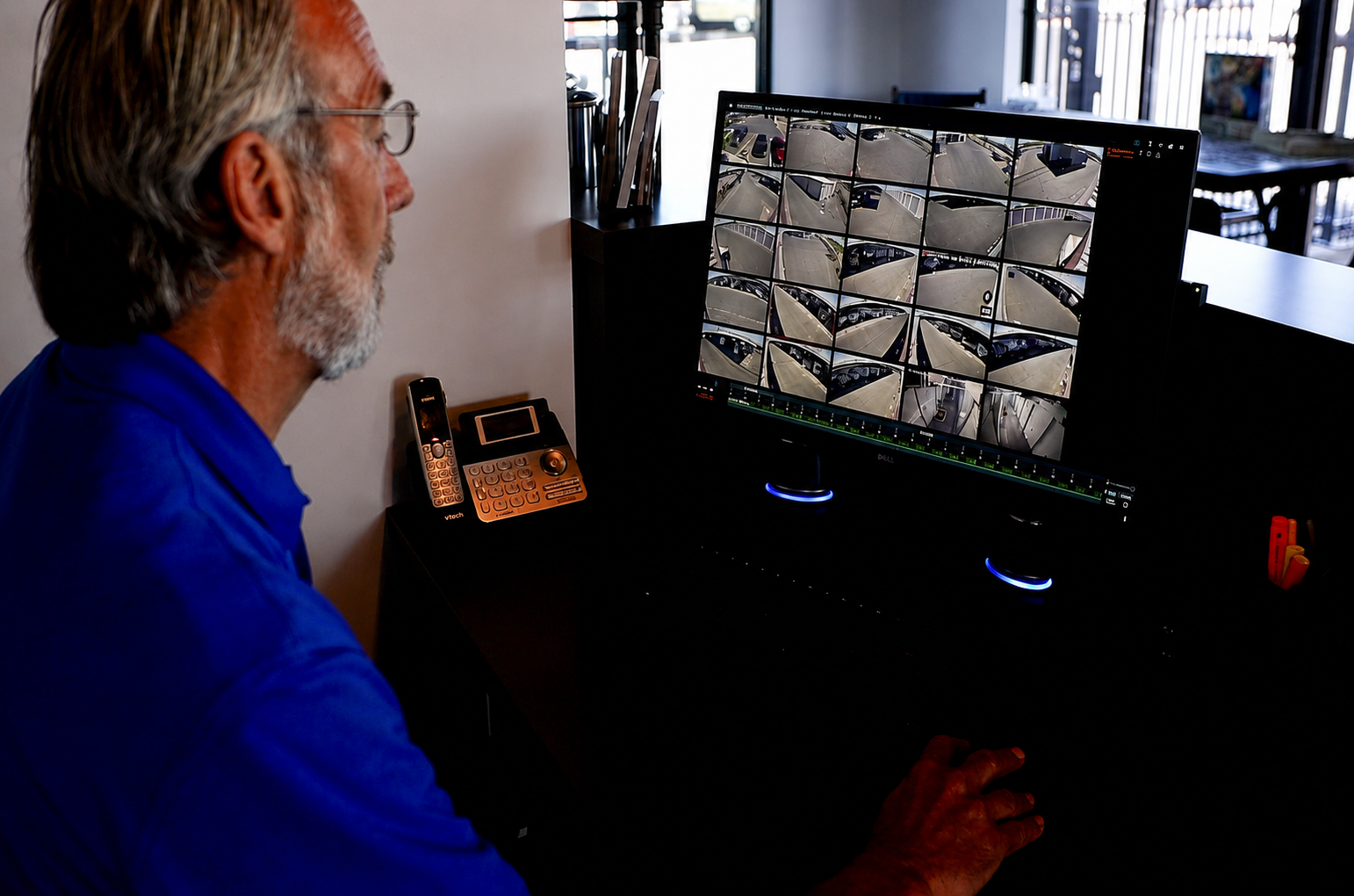 Facility team member monitoring the live security camera wall at Carefree Covered RV Storage's Chandler Kyrene Rd location