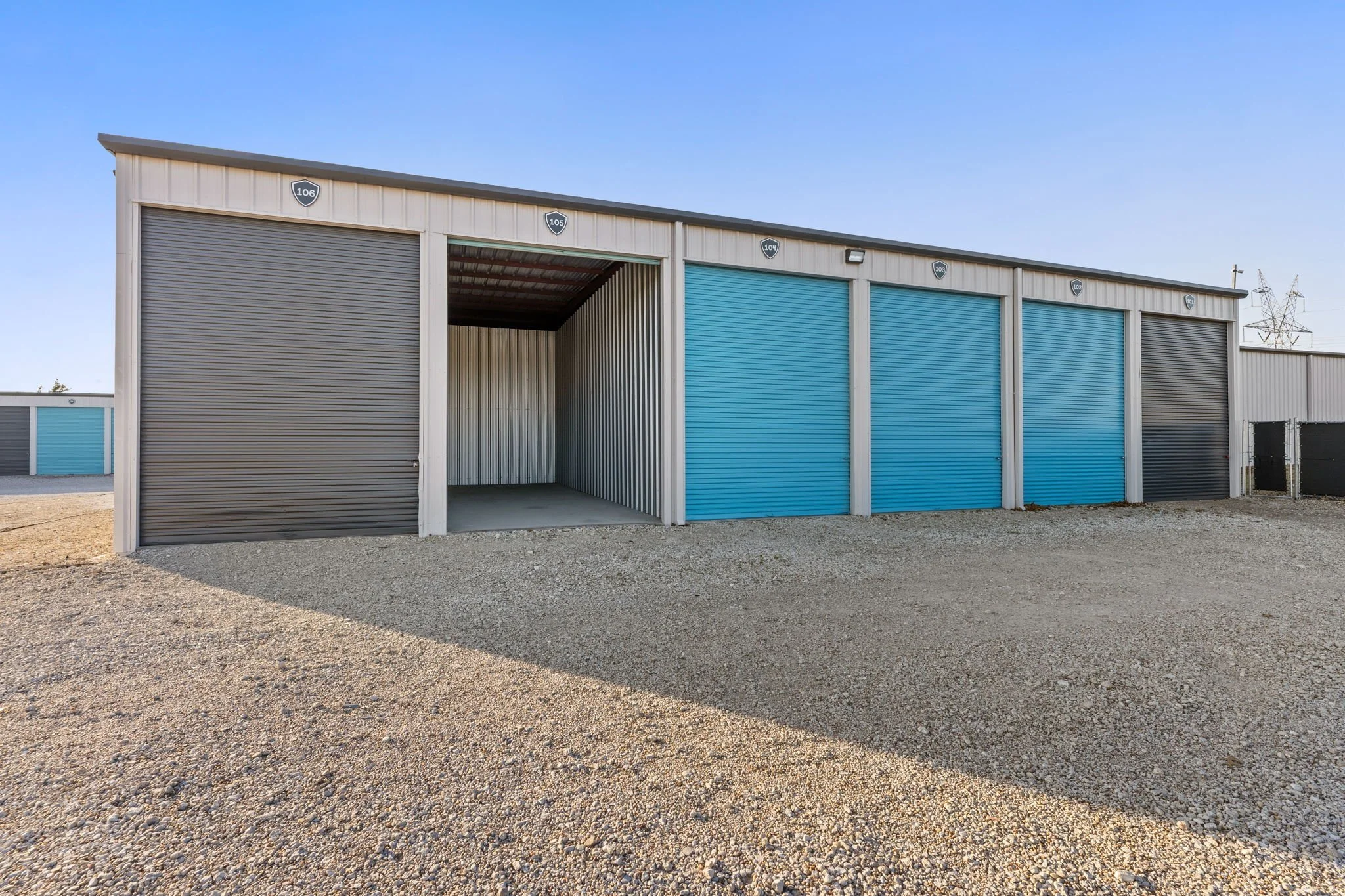 Row of enclosed boat and RV storage units with teal and gray roll-up doors at 3883 Osage Lane, Wylie, TX