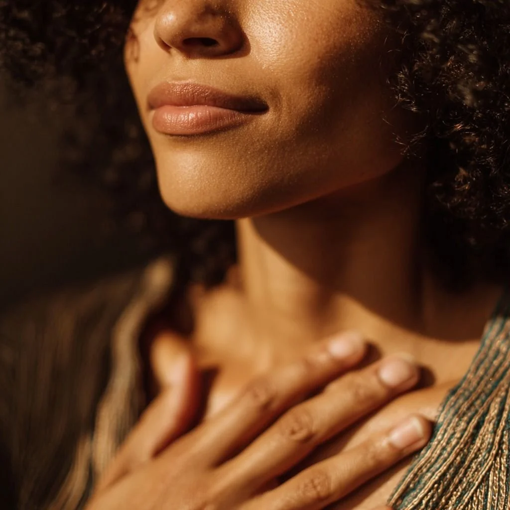 Close-up of a person placing a hand on their chest in a moment of calm self-reflection.