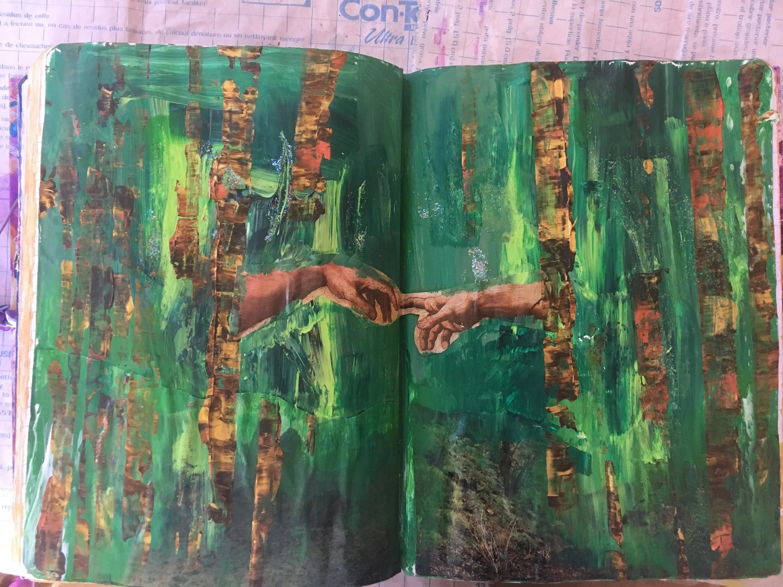 A painted representation of Michelangelo's famous artwork 'The Creation of Adam' depicting God reaching out to touch Adam's hand, set against a background of green and brown tones, on an open book or journal page.