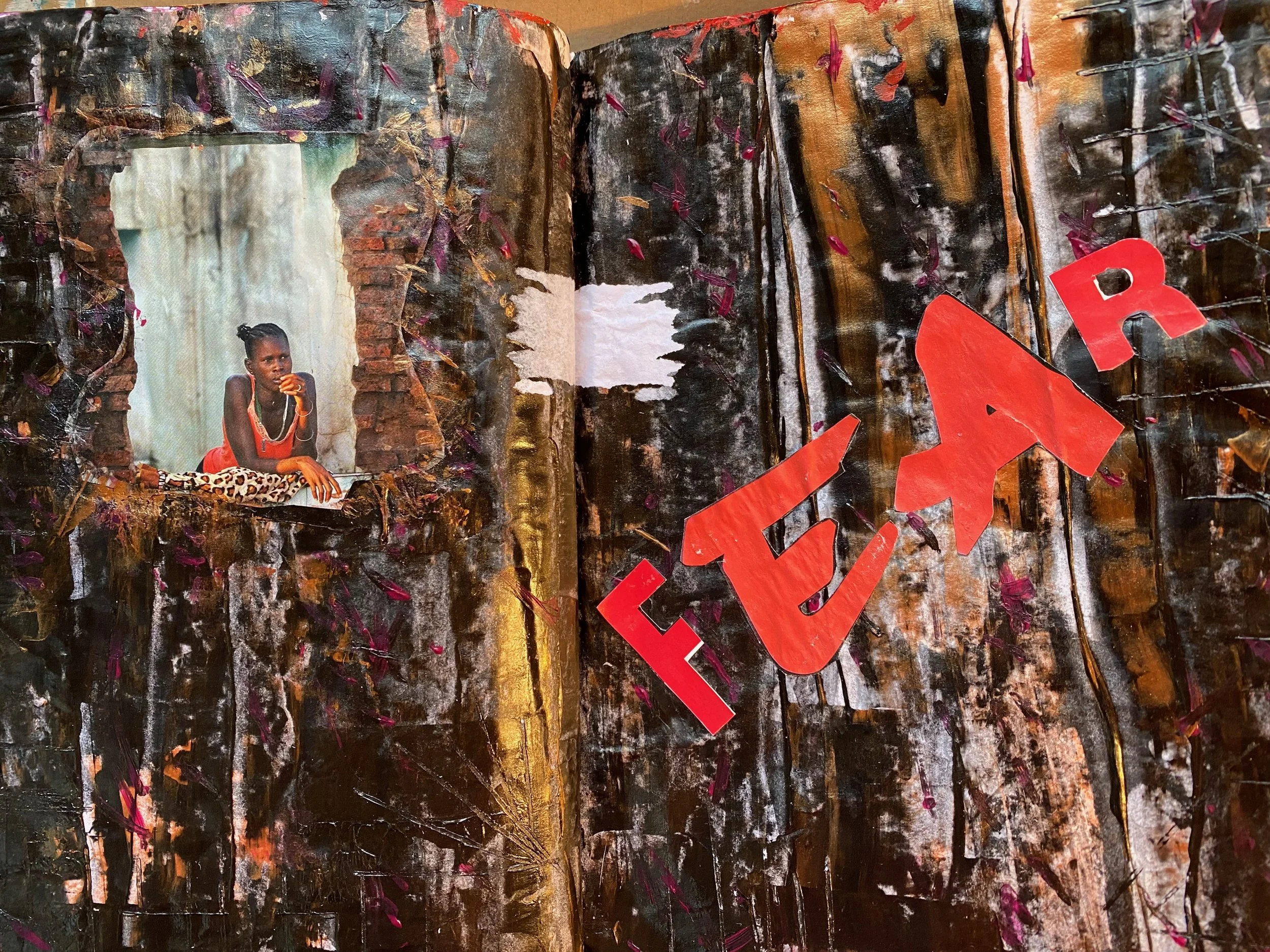 A young girl of African descent sitting on a large textured canvas with dark, earthy tones, pink accents, and a large red letter or symbol. She is wearing a red top and animal print pants, resting her chin on her hand, gazing thoughtfully.