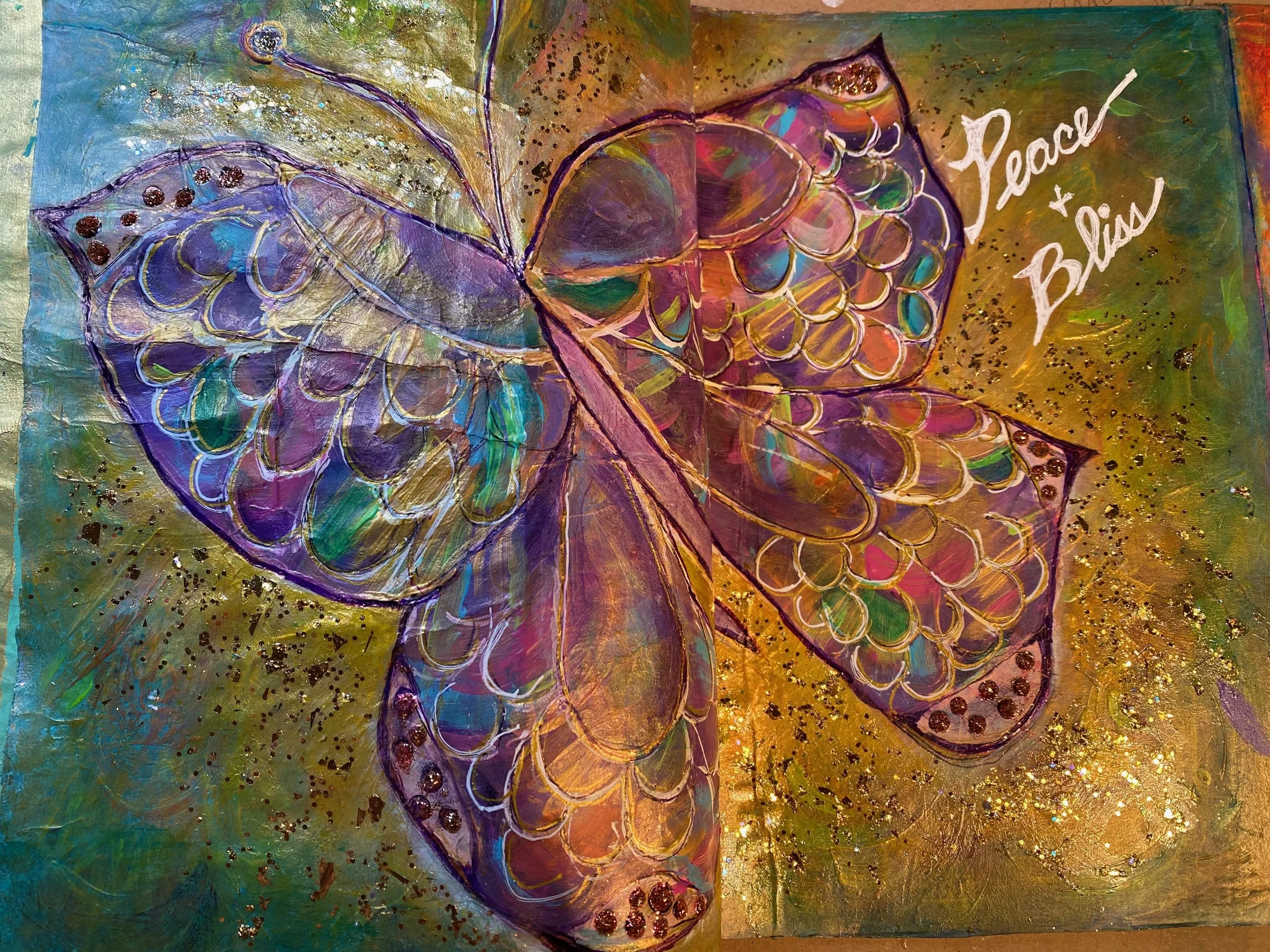 Colorful abstract painting of a butterfly with the words 'Peace & Bliss' written in white.