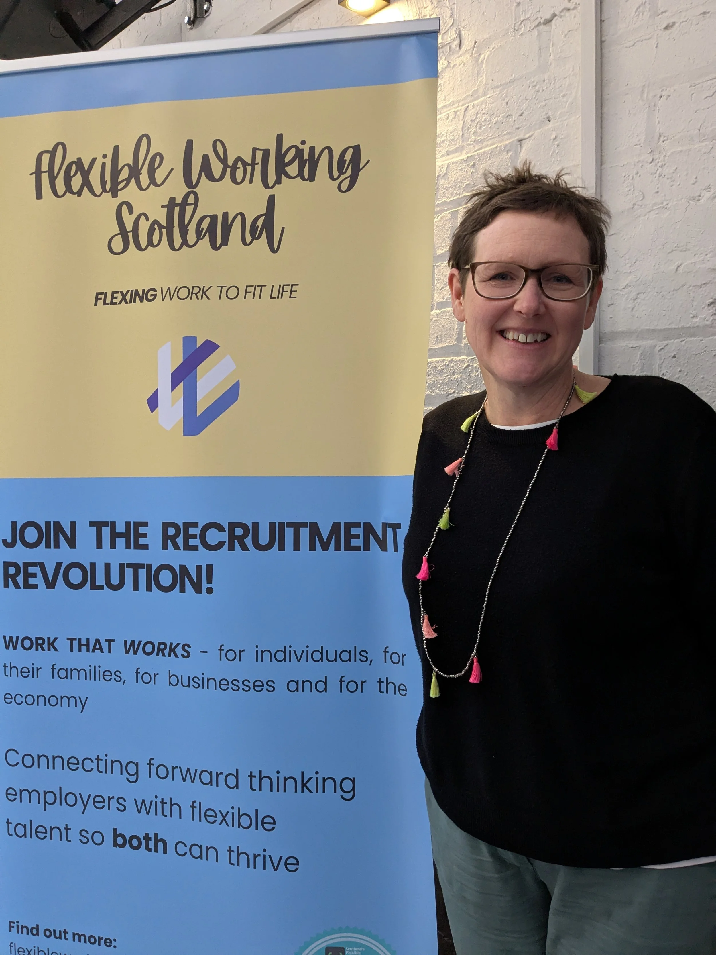 Lynn standing at the Flexible Working Scotland banner