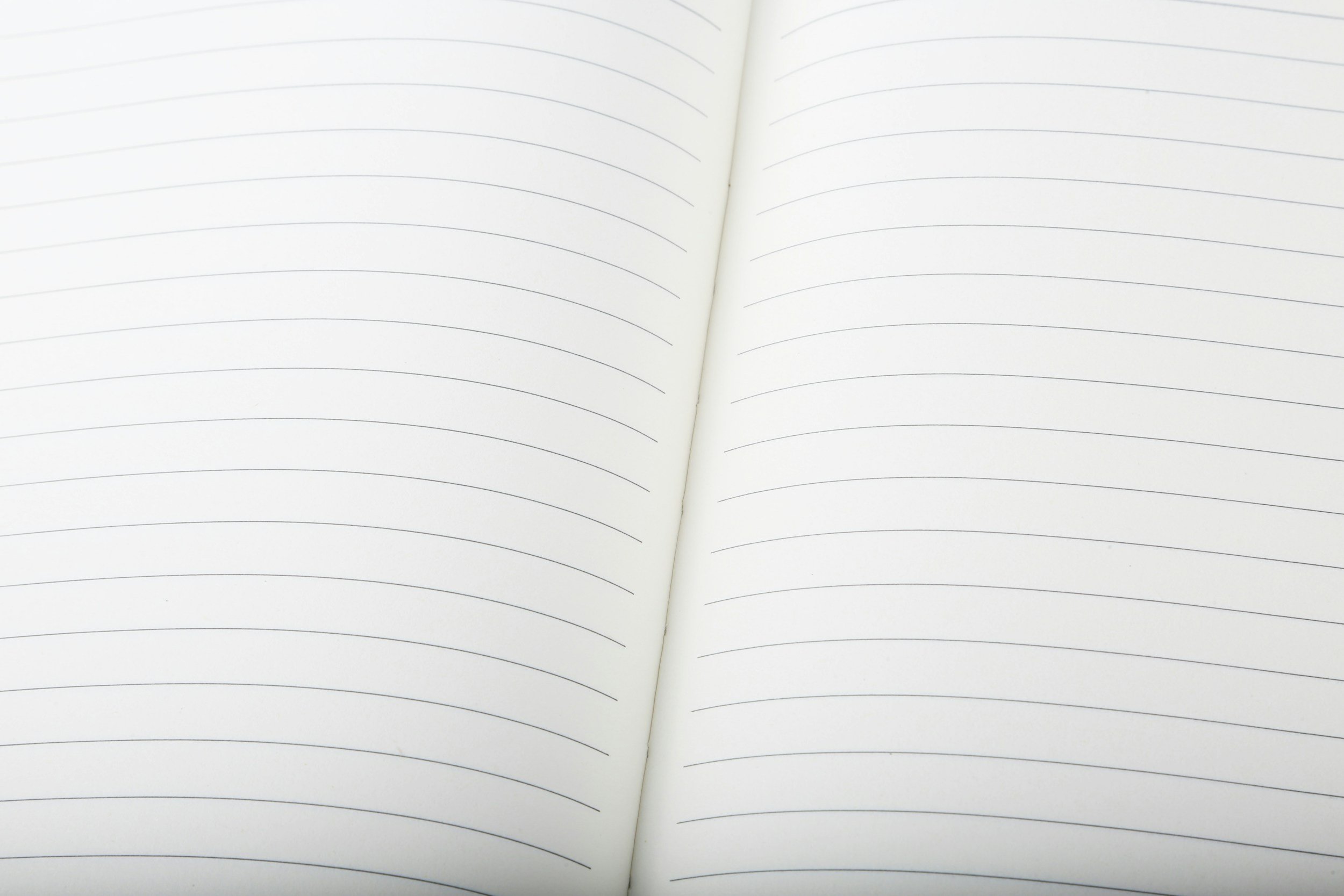 Open blank notebook with lined pages and a visible crease in the middle.