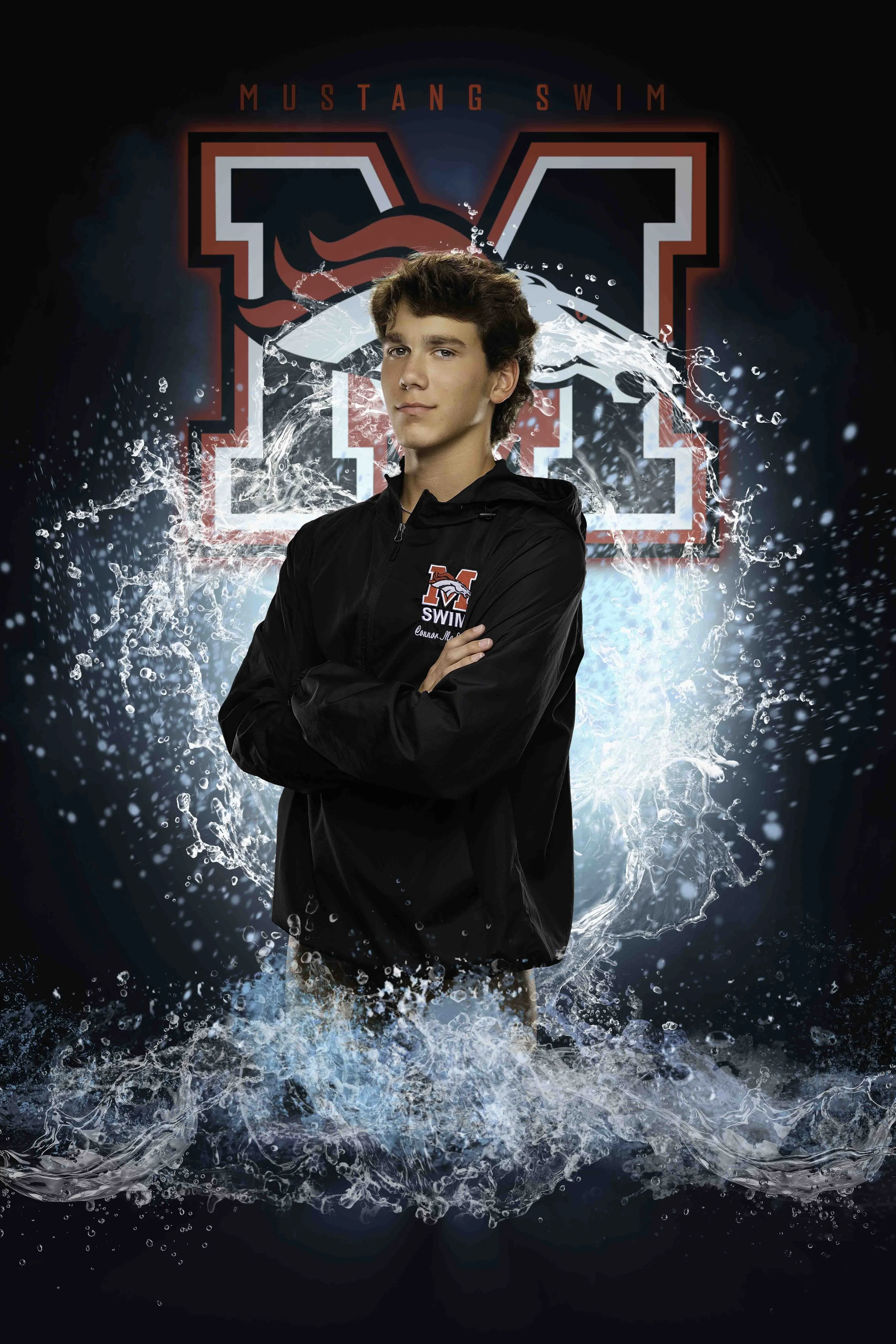 A young male swimmer with brown hair standing in front of a dark background with the word 'MUSTANG SWIM' and a large stylized 'M.' He is wearing a black swim jacket with the Mustang Swim logo and has water splashing around his legs.