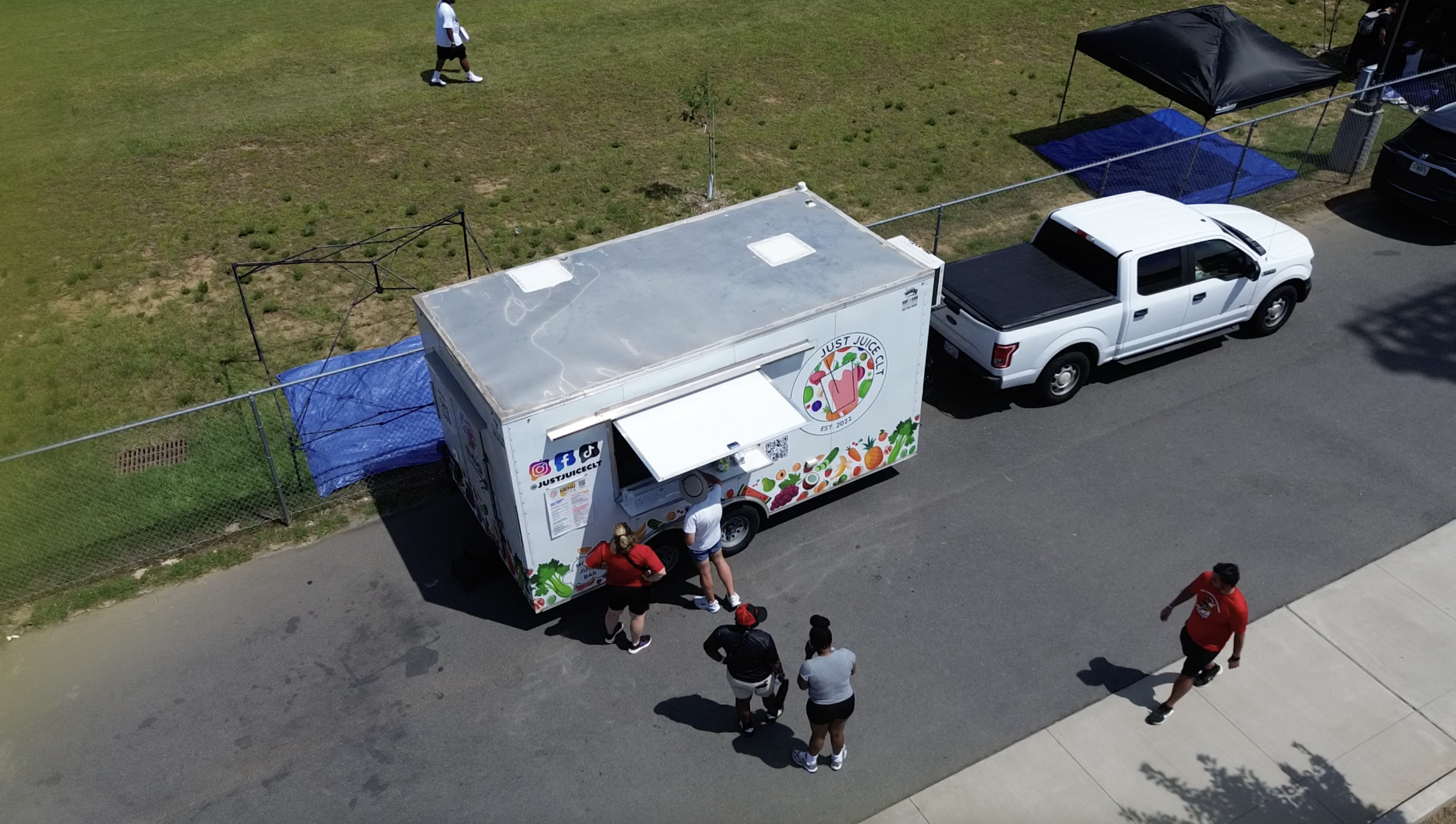 Just Juice CLT mobile juice truck serving fresh cold-pressed juices at a community event in Charlotte, NC.