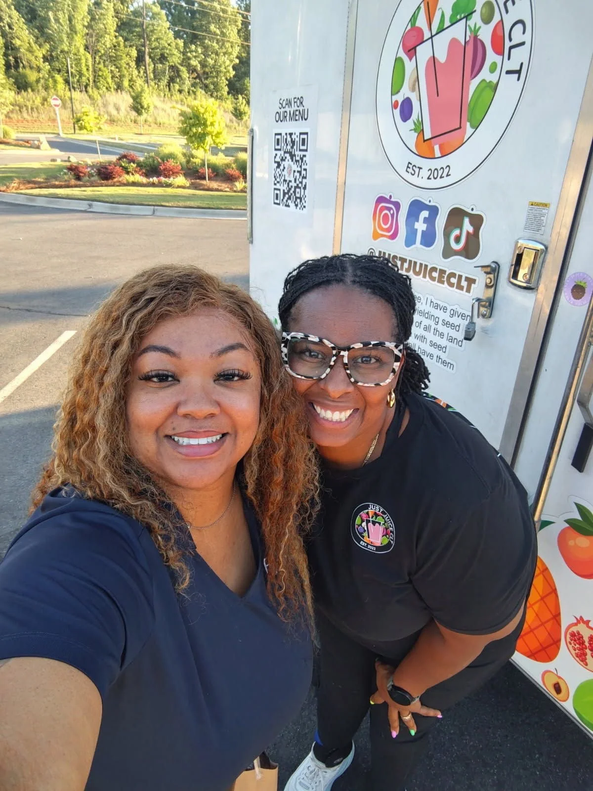 Customers taking a selfie in front of the Just Juice CLT mobile juice truck at a community event in Charlotte, NC.