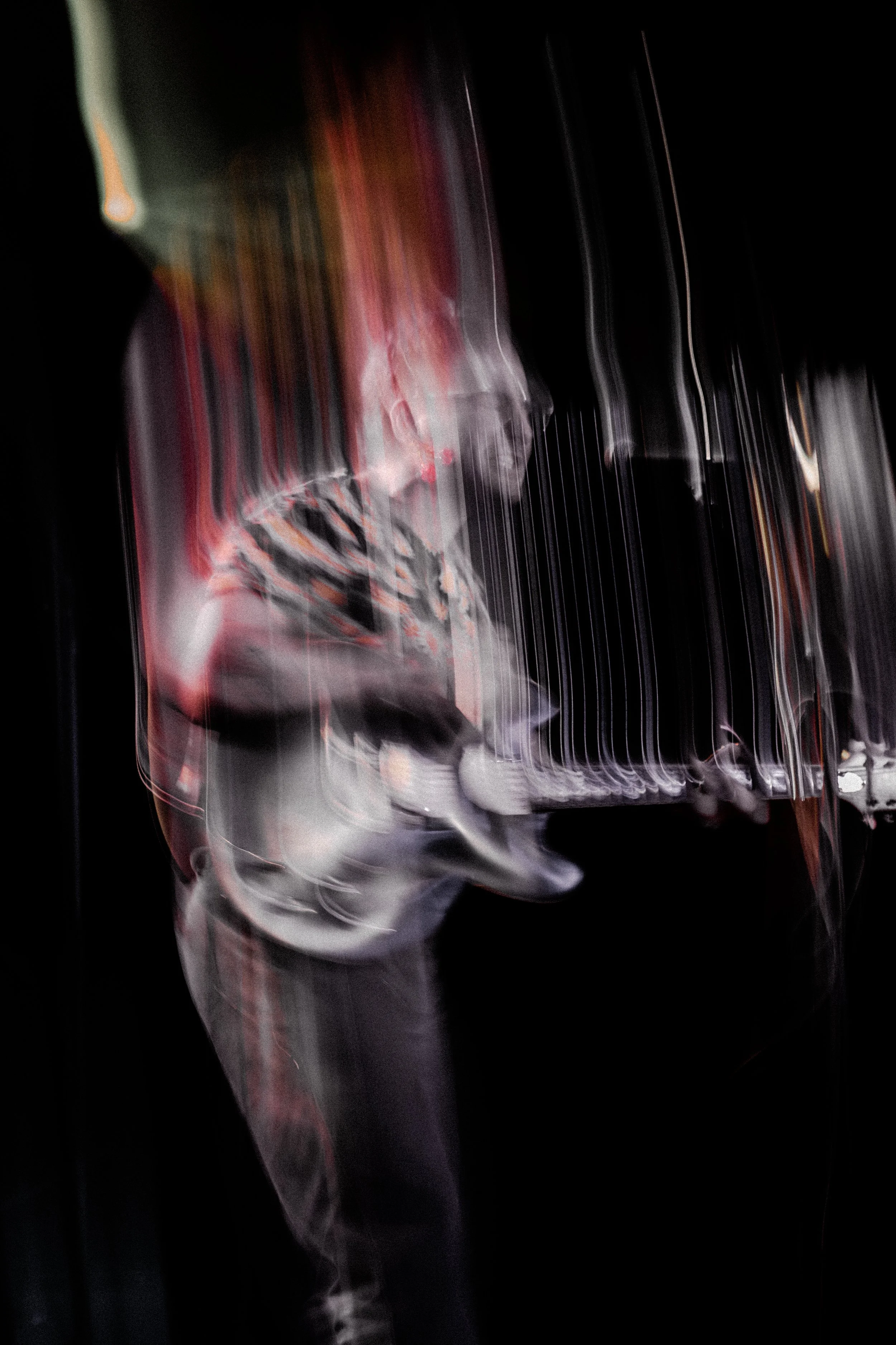 A blurry, abstract photo of a glass with drink and ice, featuring streaks of light and dark colors.